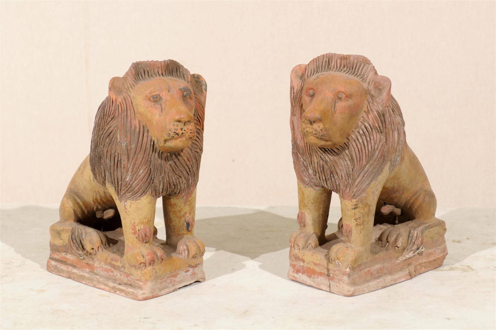 Pareja de leones coloniales británicos de terracota. Esta majestuosa pareja de leones de terracota pintada de principios del siglo XX aportará un aire de realeza a cualquier habitación.
