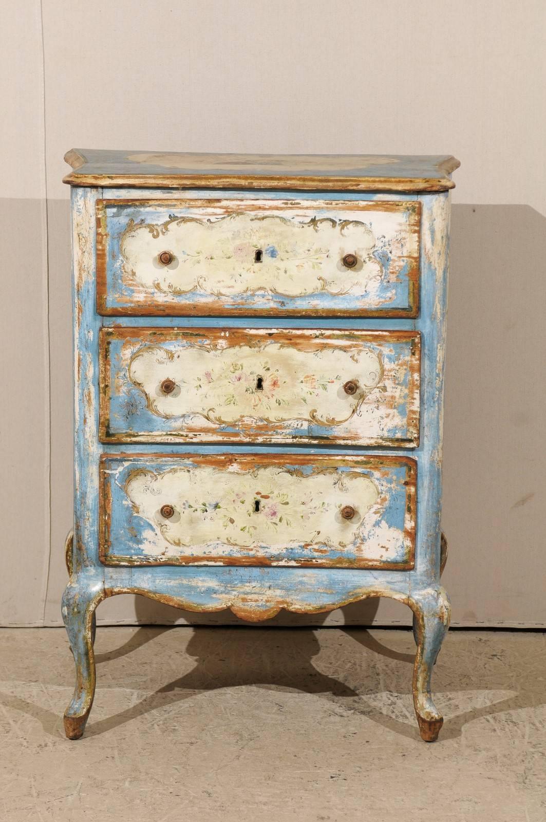 An Italian Venetian 19th century chest. This sweet Venetian commode, circa 1880s, features three drawers and its original hand paint depicting a vase with a bouquet of flowers at either chest side and roses at centre top with a surround of blue and