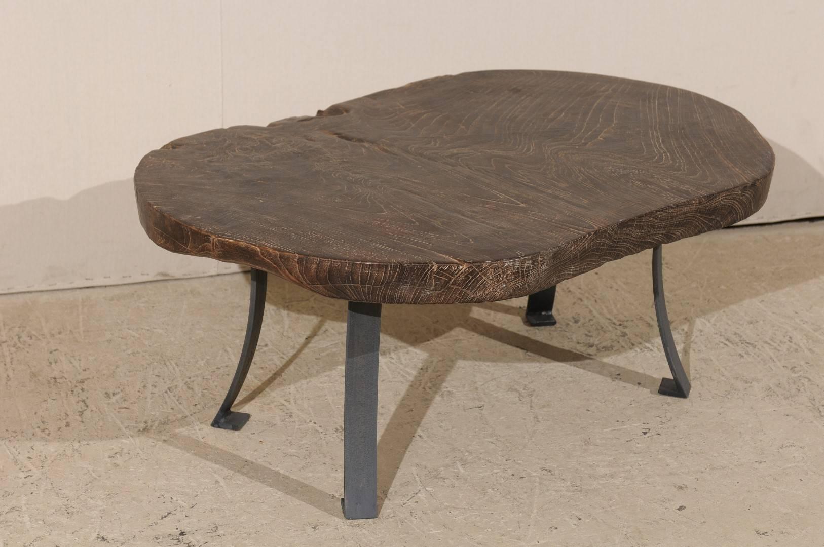 An oval shaped 19th century American burned teak wood coffee table. This one-of-a-kind, unique table is made up of a thick 2.5