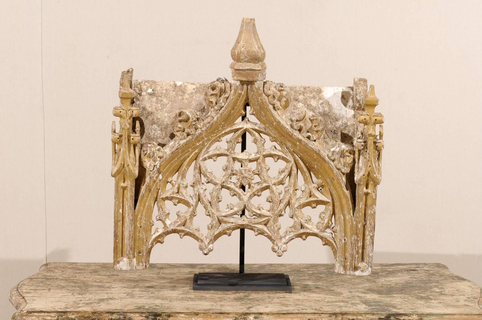 An 18th century Italian fragment on stand. This Italian fragment from the late 18th century is gilded over gesso and wood with great intricate carving details throughout reminiscent of the late Gothic. The pointed arch is decorated in its center by