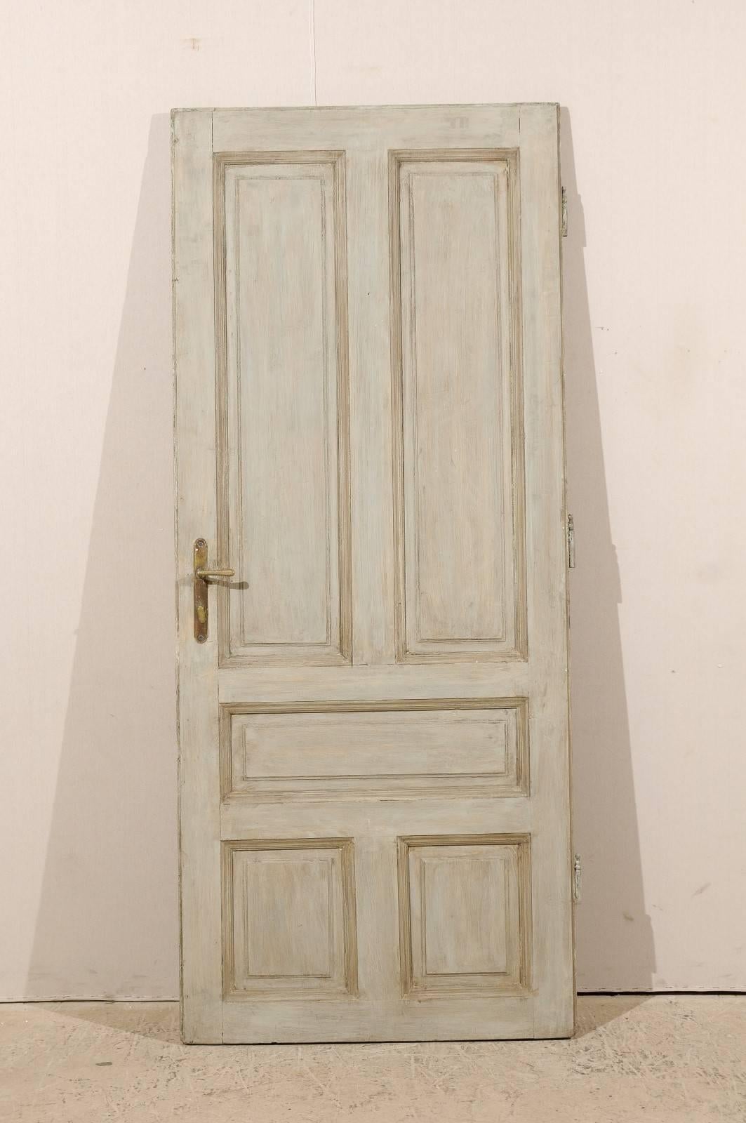 A single European five-panel painted wood door from the early 20th century. The overall color is a grey blue with a darker green brown accent on the molding creating the paneling effect. This door would look perfect as a decorative object or on a