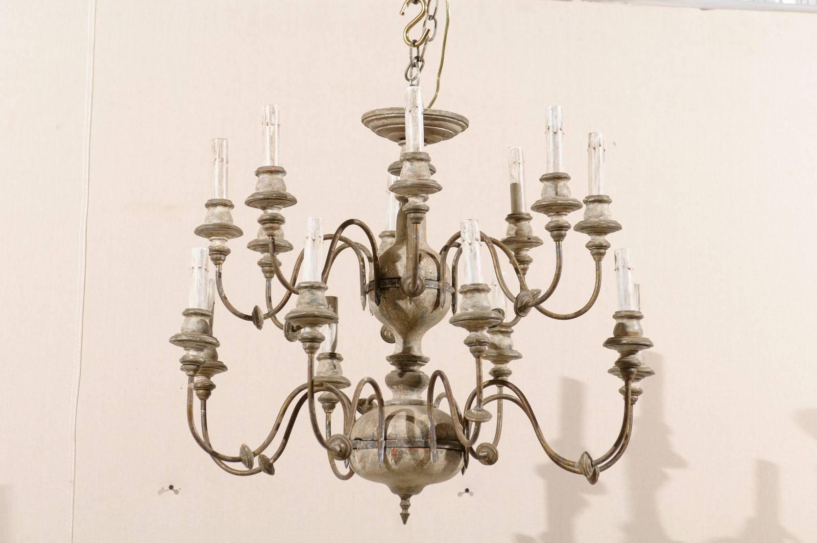 An Italian two-tiered sixteen-light painted wood and metal chandelier. This elegantly flowing 20th century Italian chandelier features a bottom and top level of swag arms and lights. These lights are on metal s-scroll swoop arms and connect to a