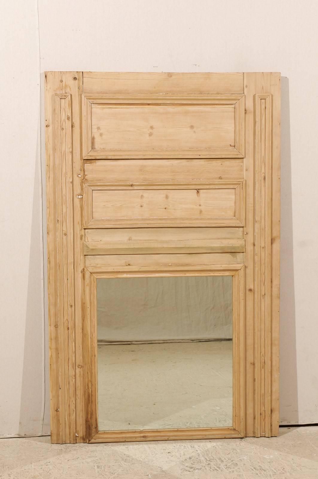 A French 19th century wood trumeau mirror. This French piece features its original glass. The surround is made of original natural pine wood. Nice wood grain is present throughout. This trumeau mirror has two decorative upper horizontal rectangular