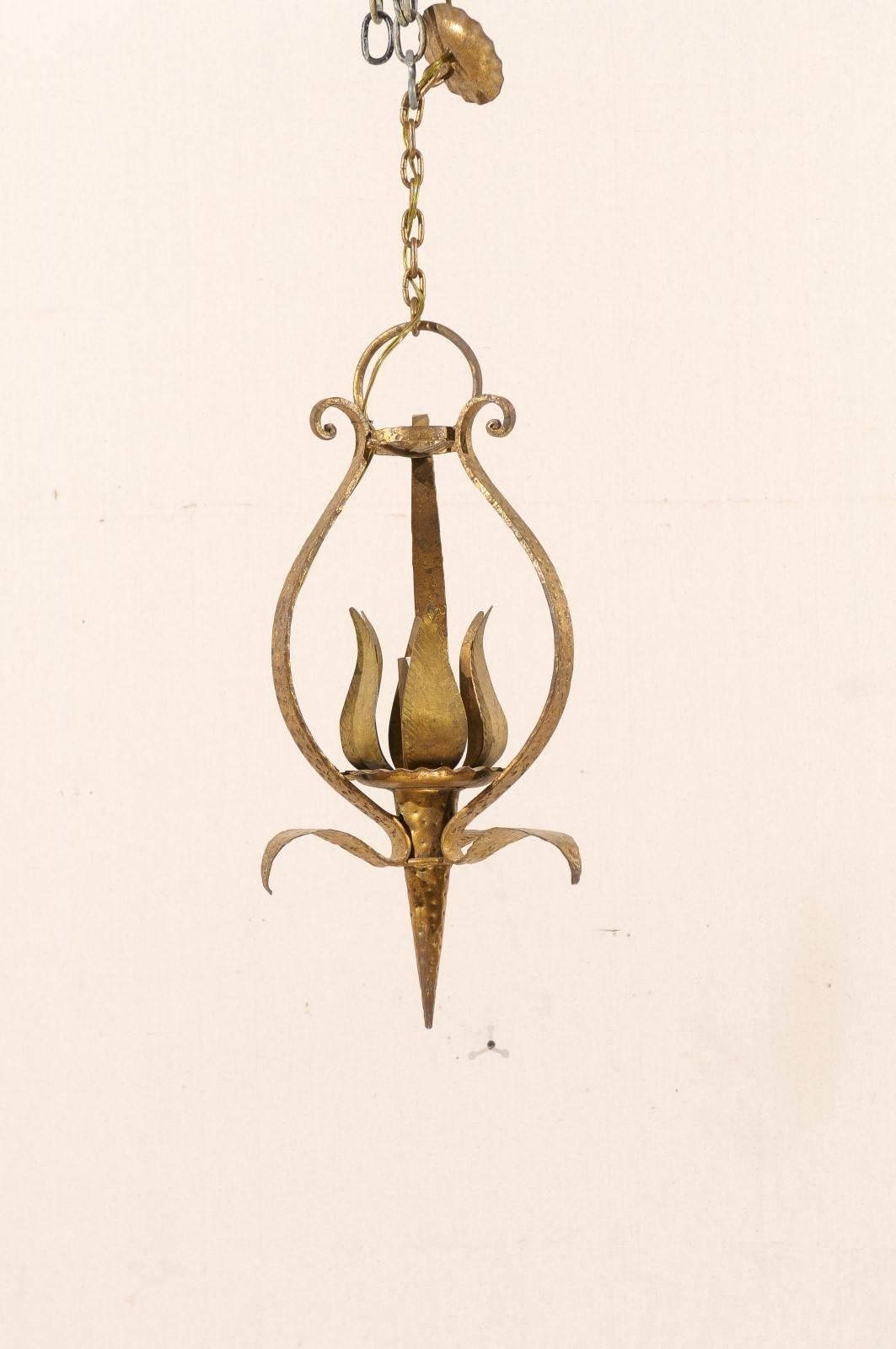 A French tulip shaped single-light gilded and hammered metal chandelier. This French mid-20th century chandelier features a modern designed central tulip ornament on cone base, surrounded with a scrolled armature. This chandelier has been rewired