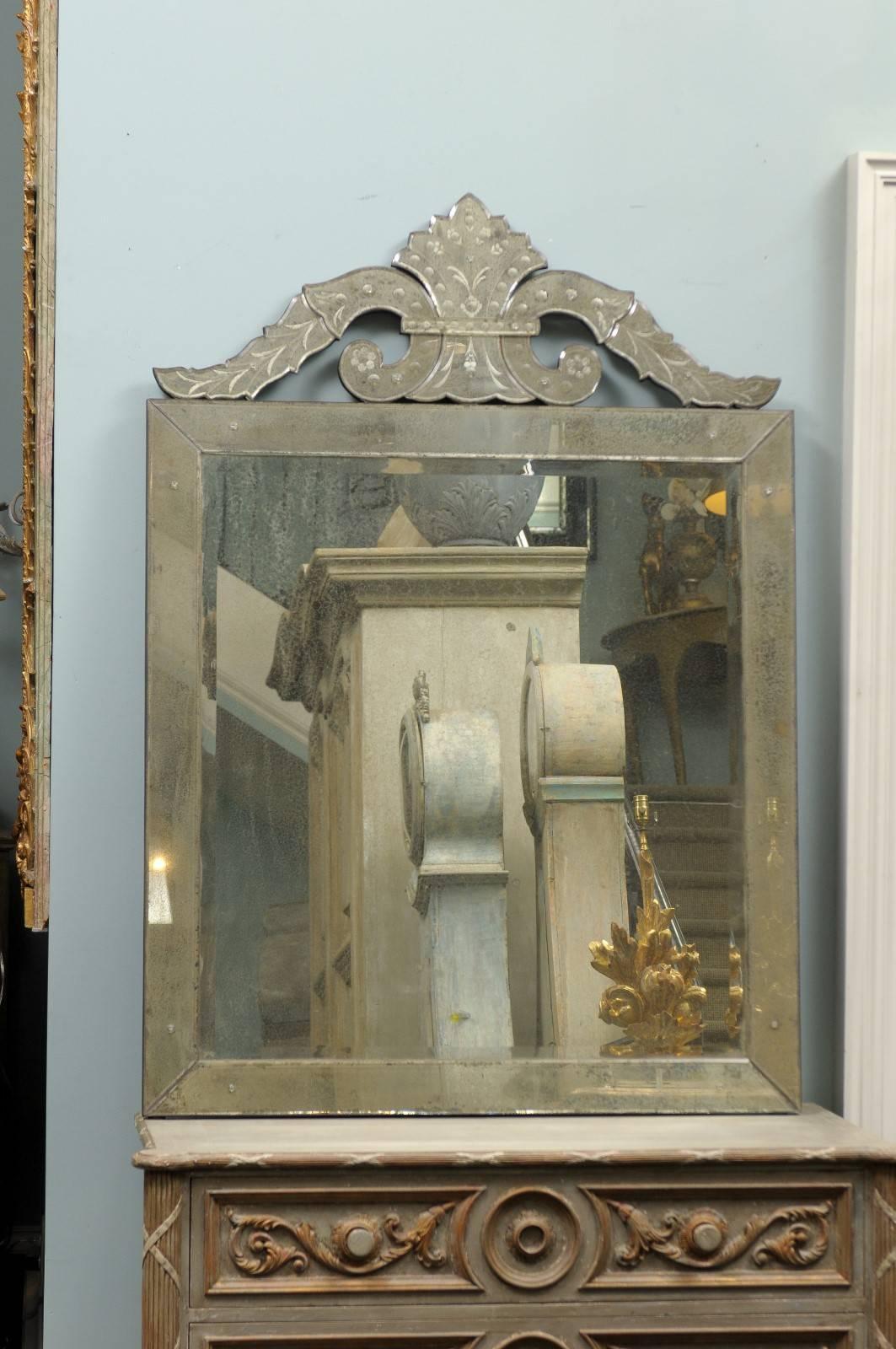 The Roma Venetian style mirror. This handmade, hand-silver Venetian style mirror features a rectangular frame topped with a nicely shaped crest with two volutes on each side ending with stylized floral motif. The central glass shows a medium