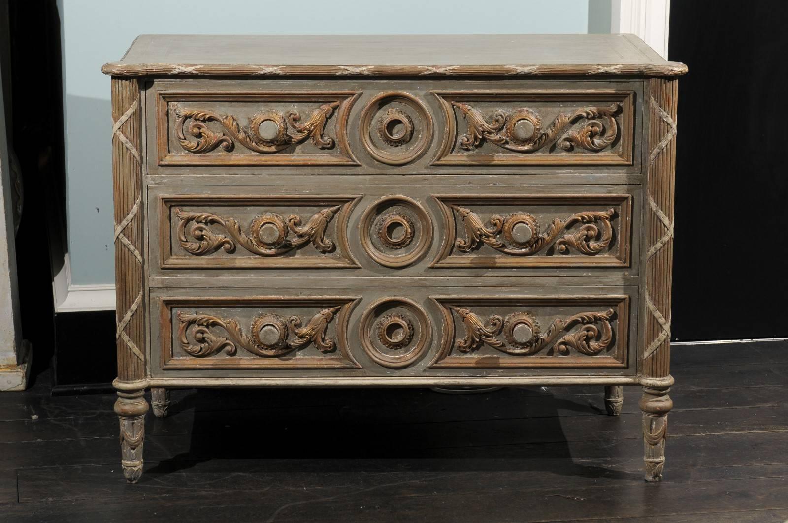 A vintage American three-drawer painted wood chest. This painted poplar chest of drawers features rinceaux motifs on each of the drawers, around a central circular medallion. The circular ring pulls allow the drawers to open easily. The sides on the