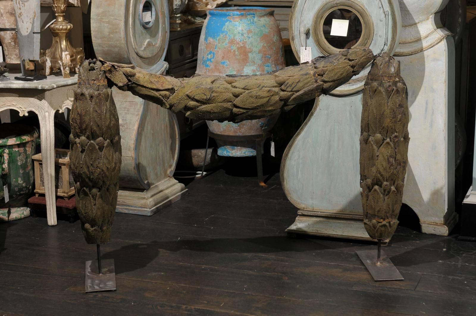 A Swedish 18th century large tole architectural swag mounted on an iron stand. This antique swag came from a building in Sweden. This unique piece consists of a rich foliage motif that appears to be draping on its stand. The general color of this