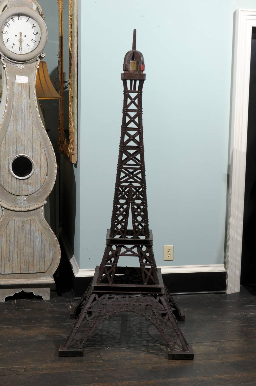 A tall 6.5 foot tall Eiffel Tower replica statue.  This iron replica of Paris' famous Eiffel Tower is custom made of various vintage pieces. It is heavily weighted, with a nice age. The proportions are nicely respected, the color is of a dark brown