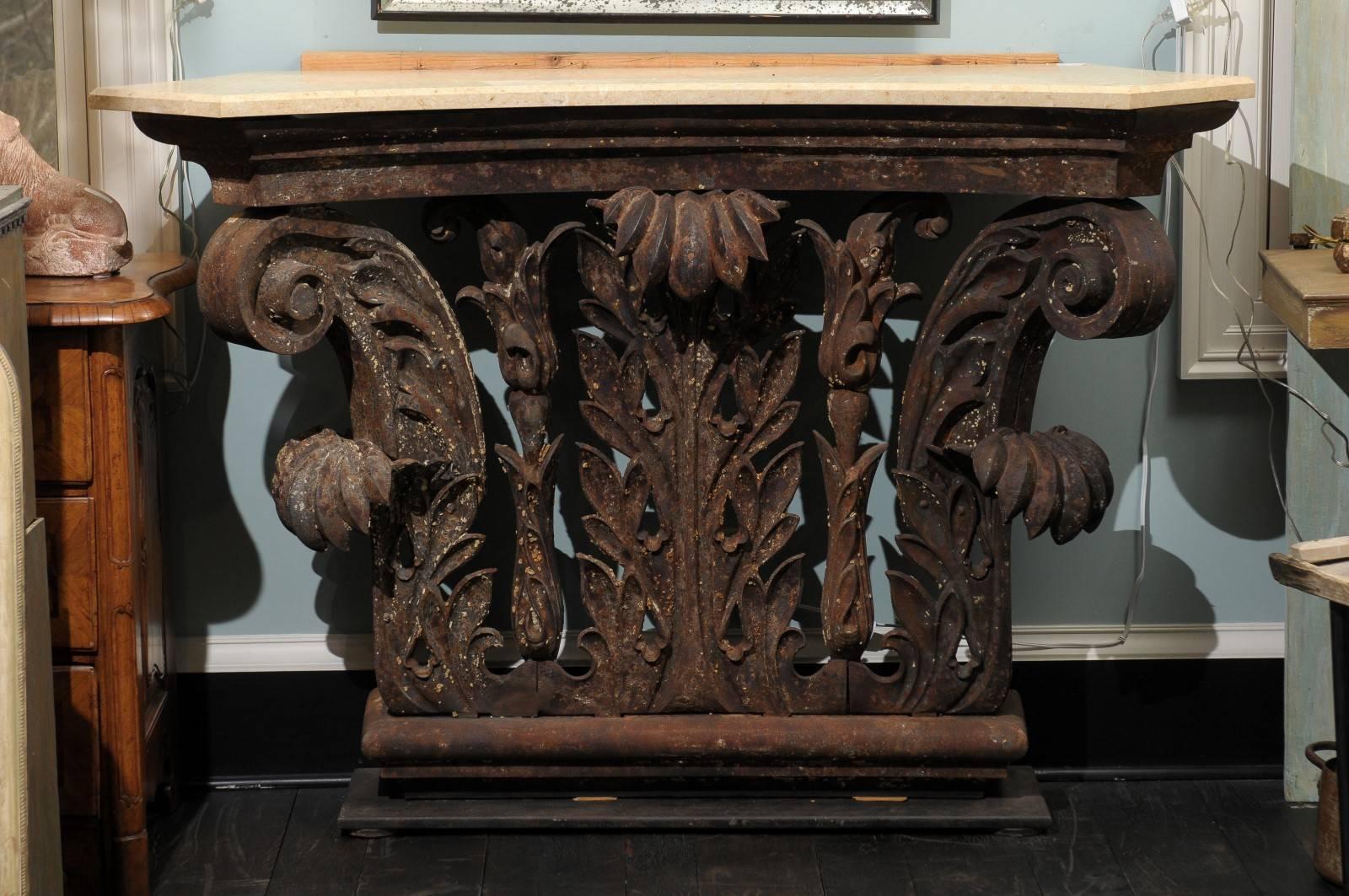 A fantastic iron architectural Corinthian capital fragment from a New York building made into a console table. A custom travertine top has been added. (Travertine looks a lot like marble). This early 20th century architectural piece features its