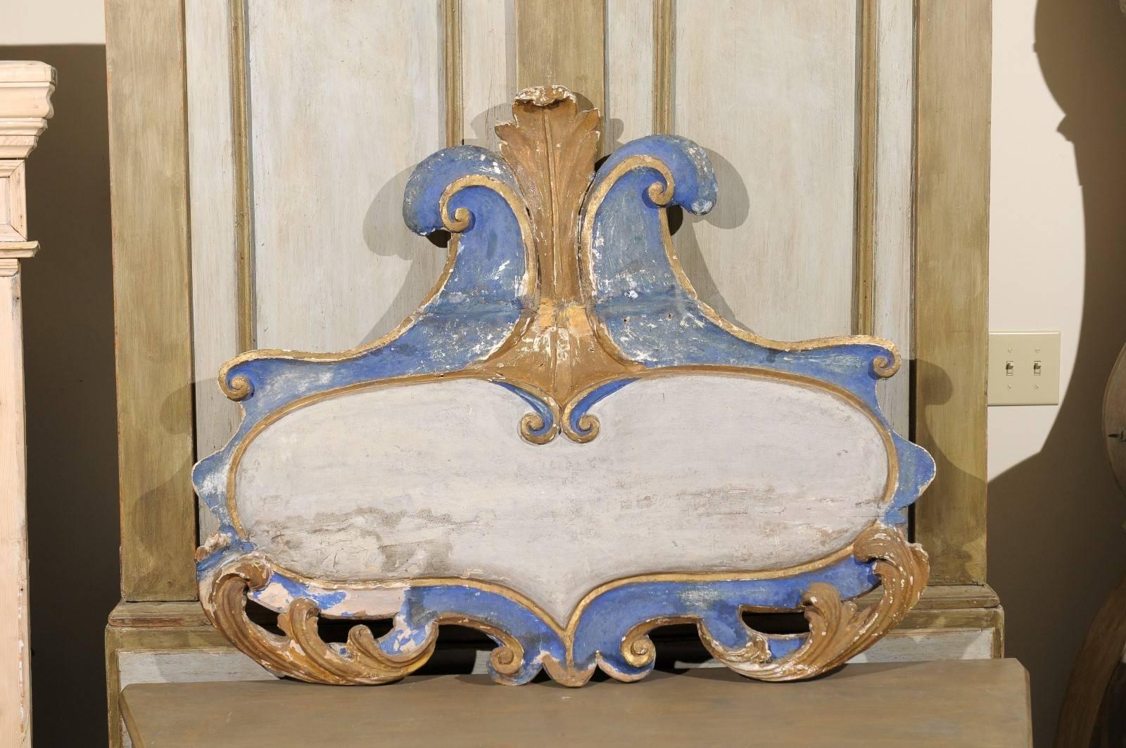 A 19th century Italian rococo style carved wooden cartouche wall decoration with original paint. This Italian wall ornament features two volutes in its crest from which stems an acanthus leaf, echoed in the lower part on each side. Very nice