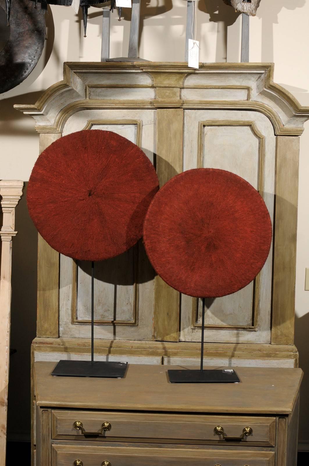 One Isicholo African Hats. This red-ochre dyed women's hat is from the Zulu people, South Africa, and is made of a combination of cotton, human hair over a grass-fiber basketry frame. Traditionally reserved for married women, these hats are now worn