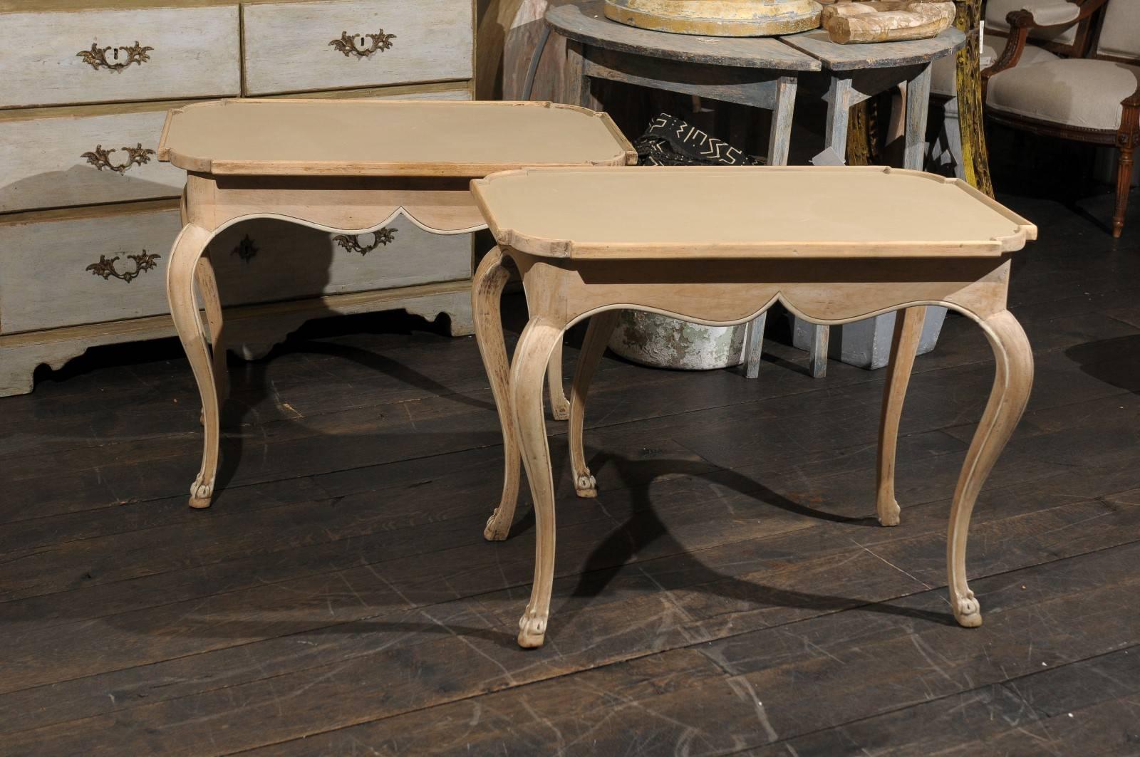 A pair of French painted wood tray top tables. This pair of French tray top side tables are each adorned with a rectangular top nicely curved in each corner, and a nicely scalloped skirt in the front and back sides. These French late 20th century