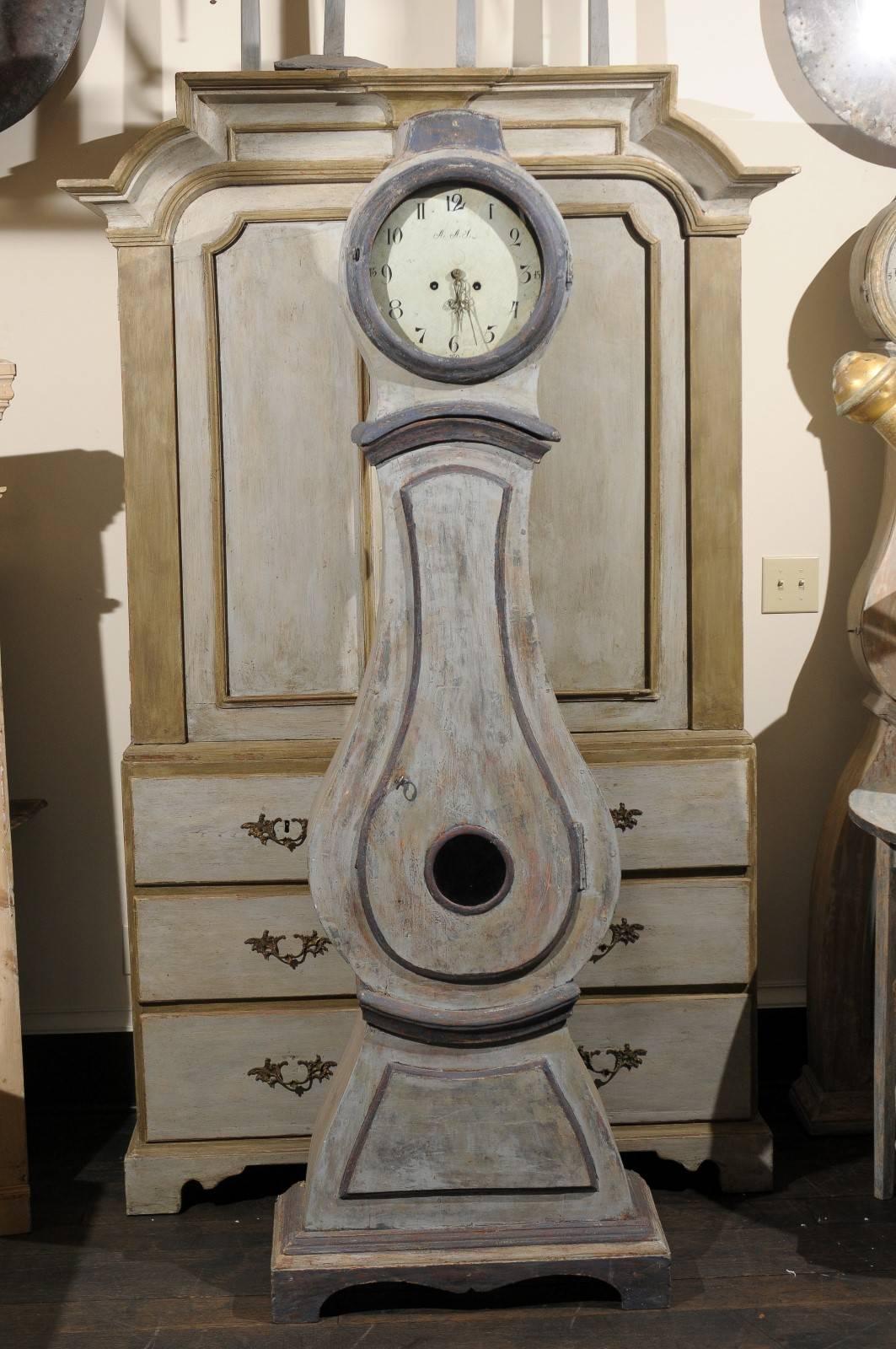 A 19th century painted wood Swedish long-case clock with distinct curvy rain drop shape. This clock retains it's original metal face, hands and movement. 
 This tall Swedish floor clock is painted an overall mix of grey tones with a mix of plum