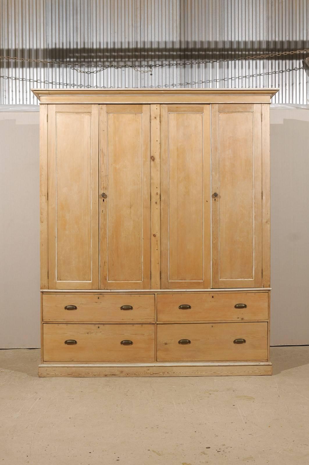 A large English vintage natural wood cabinet. This oversized English cabinet from the mid-20th century features four doors over four large drawers. The top doors open up to multiple adjustable interior shelves. This cabinet breaks down into two