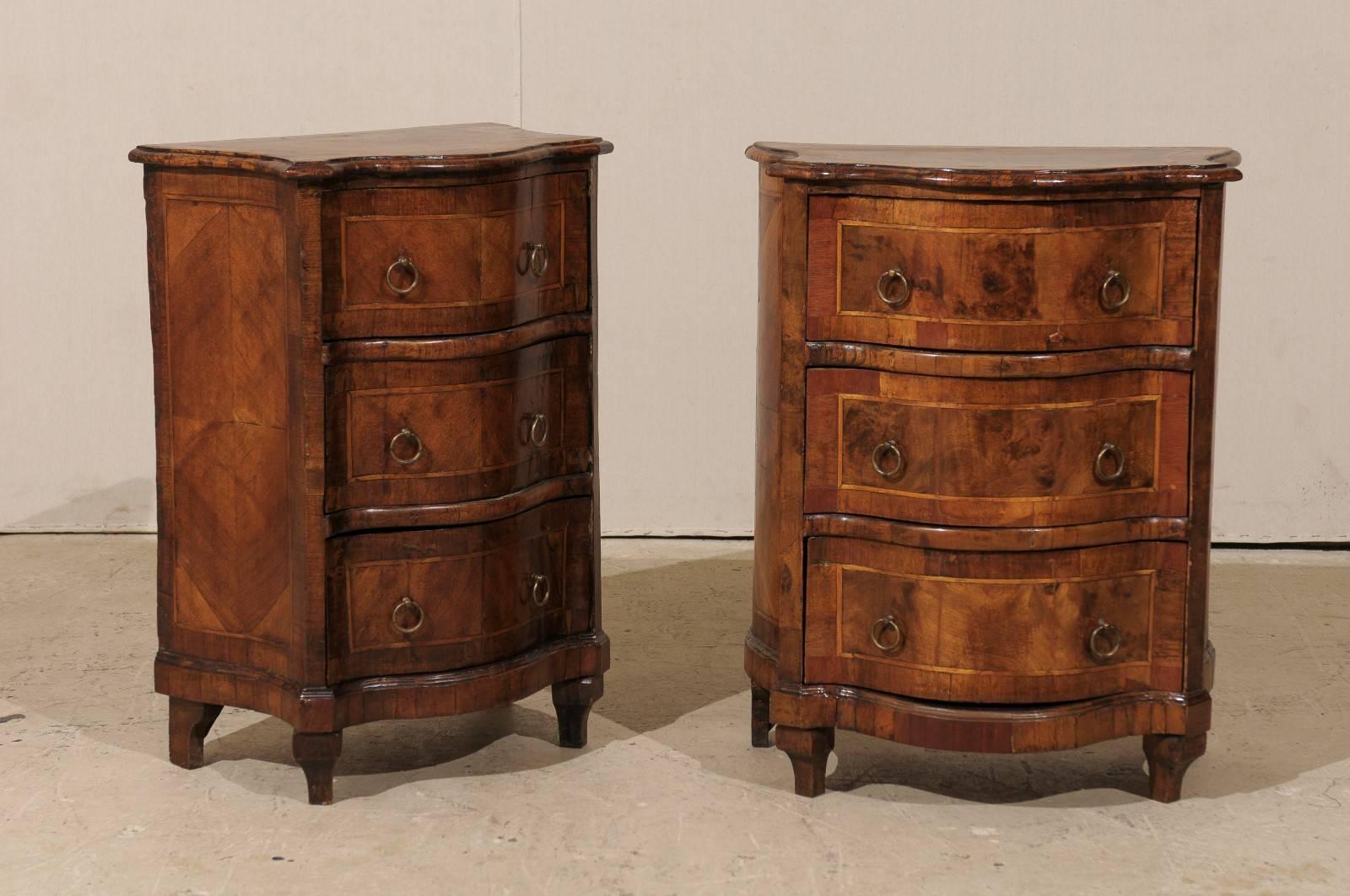 A pair of Italian early 19th century small serpentine Marquetry Commodini. These exquisite petite sized Italian chests feature three drawers with banding and ring pulls allowing the drawers to open easily. The top and sides are also inlaid with the