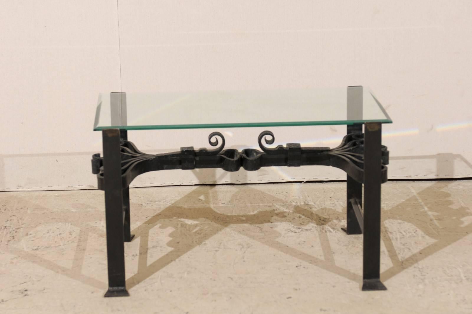 Fer forgé Table basse italienne en fer forgé de couleur noire avec plateau en verre et volutes ornées en vente