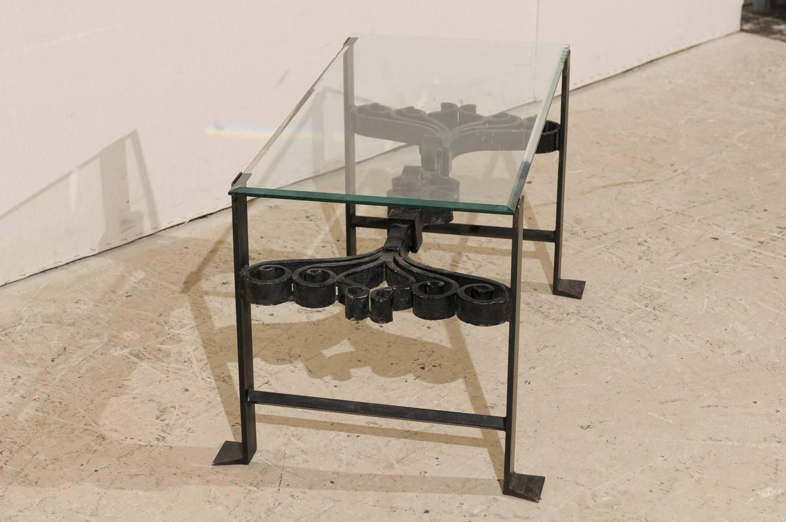 Table basse italienne en fer forgé de couleur noire avec plateau en verre et volutes ornées en vente 2
