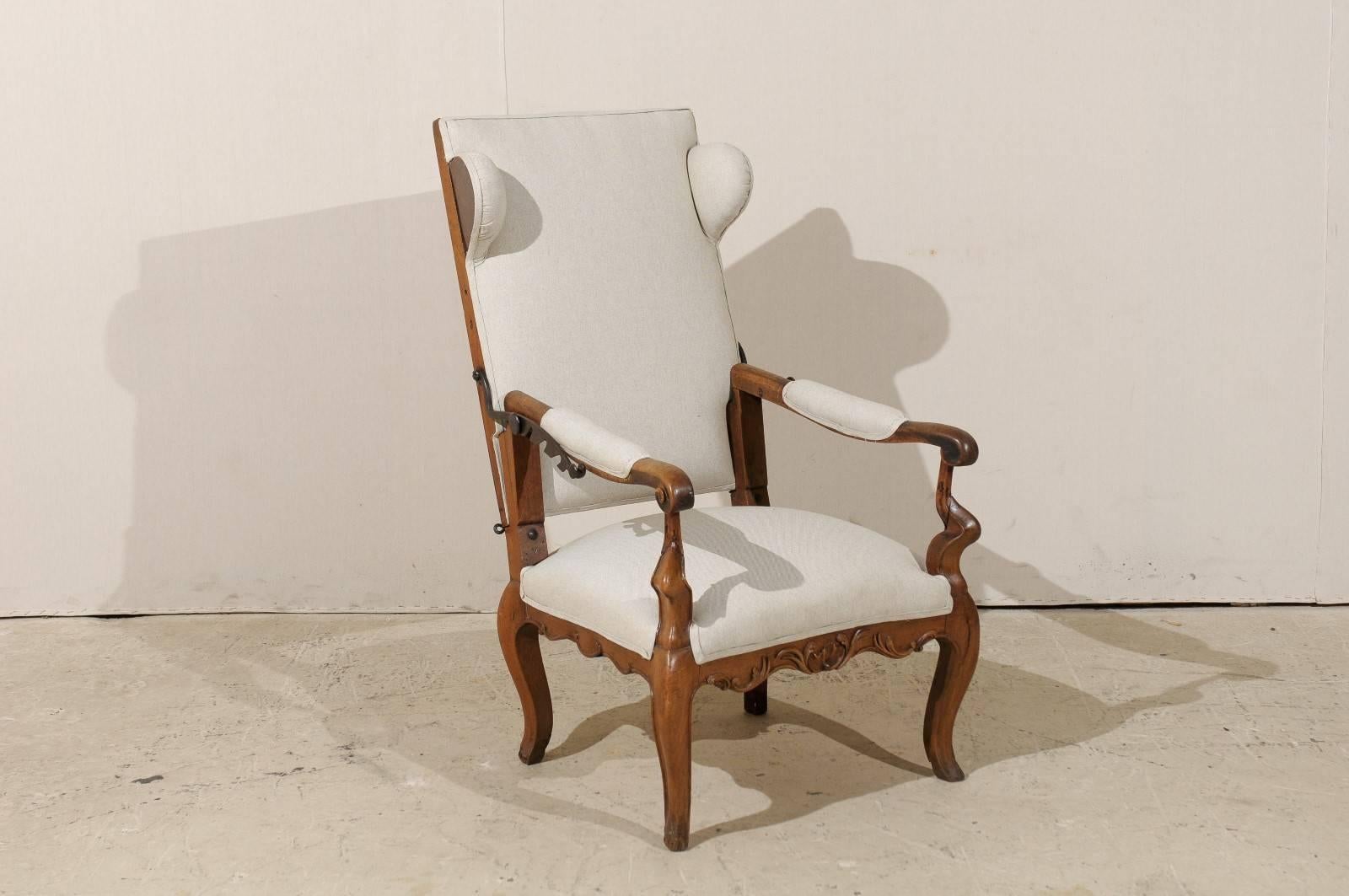 A wooden 18th century Italian reclining armchair. This unique Italian armchair features a reclining back with head rests at either side. The arms are upholstered and feature carved wood scrolled knuckles. This Italian armchair also features an