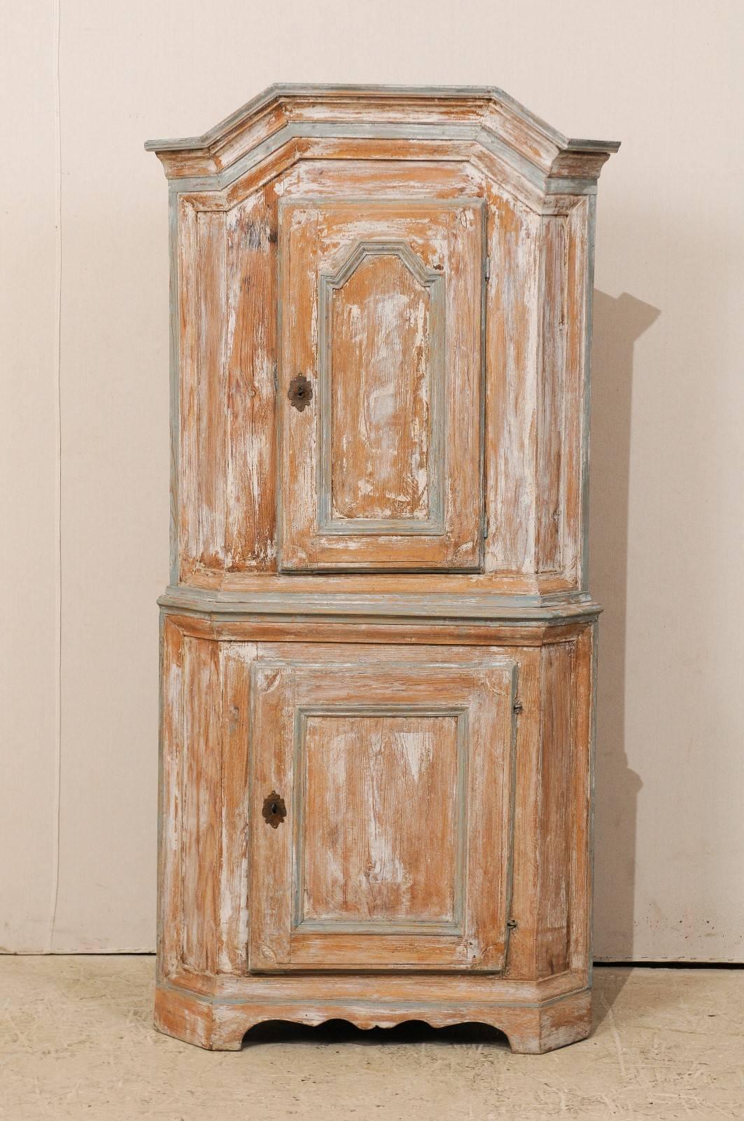 A Swedish mid-18th century late Baroque corner cabinet. This Swedish Baroque cabinet, circa 1730-1740, features a pediment cornice, carved cupboard doors and scalloped base. There is a single top cupboard board with a single bottom cupboard door and