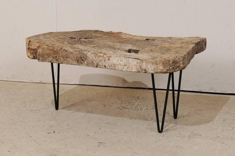 A custom coffee table of old Spanish wood. This rustic yet chic coffee table is made up from the top of a 19th century Spanish work table. The holes within the tabletop are where the feet were originally attached, and gives the top great character.