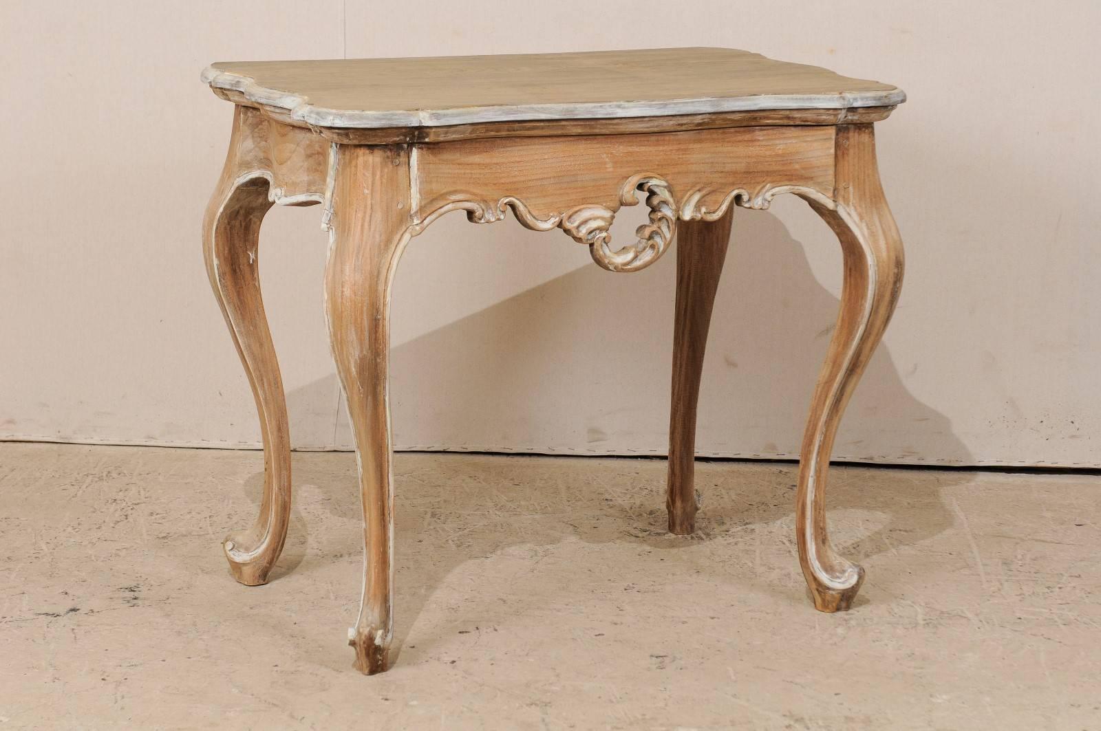 A Brazilian wood accent table. This Brazilian table from the 20th century, features a nicely carved and pierced apron, cabriole legs, and carved edging along top. The table has a natural wood finish with a lighter wash along the top and highlighted