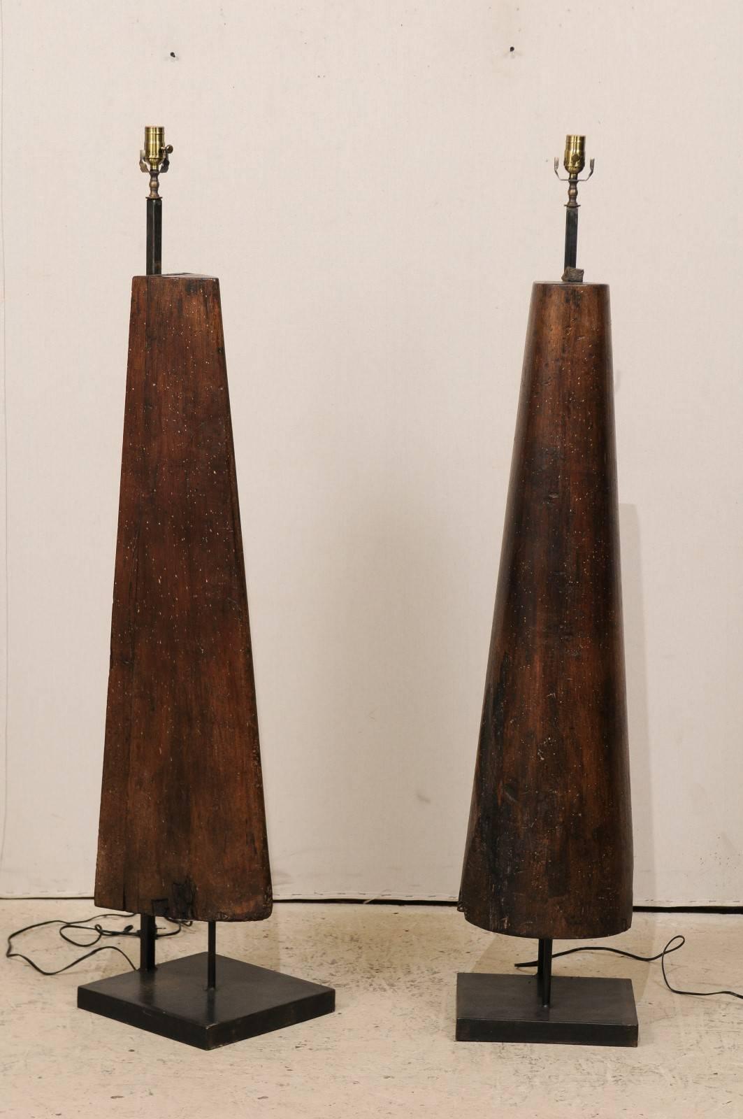 A pair of modern style French floor lamps from the mid-20th century. This pair of French mid-century floor lamps have been fashioned out of old industrial forms and set onto newer, custom metal bases. These floor lamps have a rich brown color with
