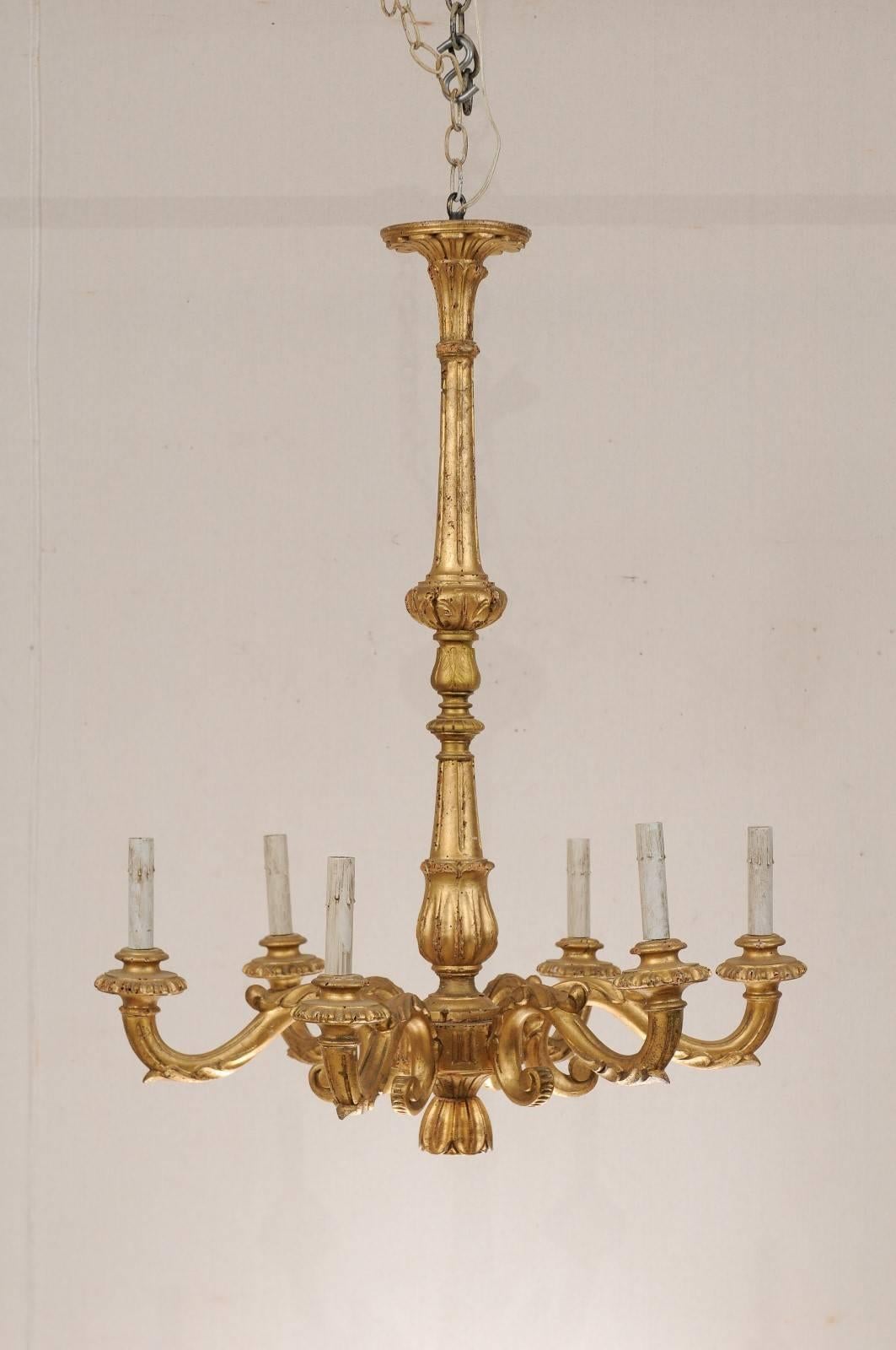 An Italian six-light gilded chandelier. This simple yet elegant early 20th century Italian chandelier would add charm to any space. This piece has an elongated slender central column that reaches from the top to the bottom and has nice acanthus leaf