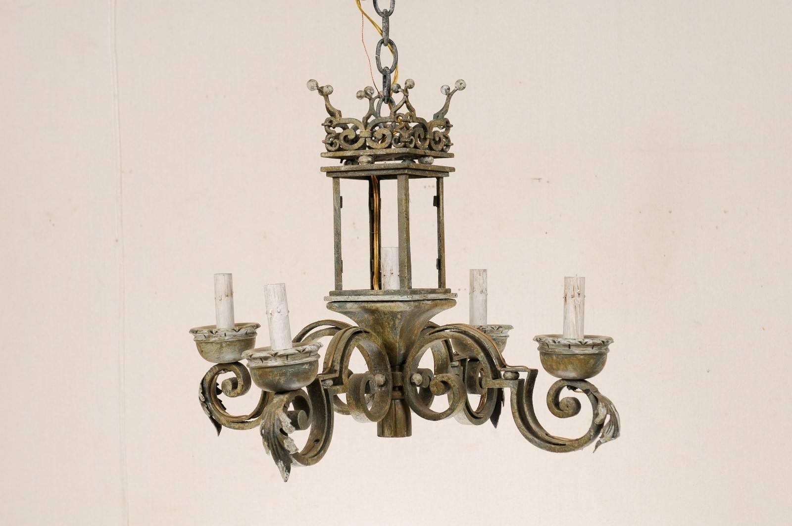 An Italian five-light chandelier. This hand-forged Italian chandelier from the mid-20th century has a unique lantern style central body. Scrolled arms emerge from the base of the central rectangular shape presenting lights from all four sides with