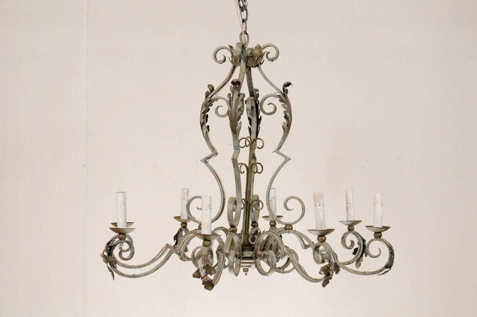 A French painted iron eight-light chandelier. This vintage French chandelier is decorated with scrolls throughout which are adorned with acanthus leaves. This chandelier is from the mid-20th century. This French chandelier has also been rewired for