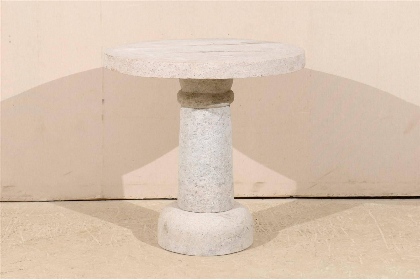 A round hand-carved granite contemporary pedestal table. This round granite table would be perfect for indoor or outdoor use. It is made of three separate pieces. This table was made in India. We currently have three of these tables available. As