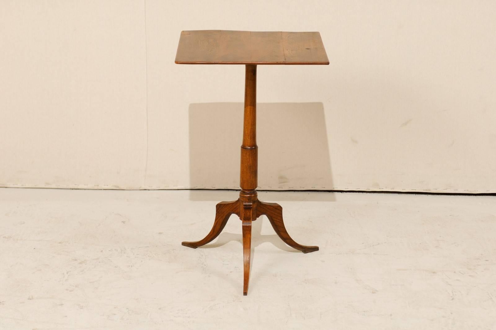 A Swedish 19th century wood side table. This Swedish table of elmwood, from the mid-19th century, features a square shaped top and slender pedestal column which that is raised upon delicately sloped tripod feet. This table is in very good antique