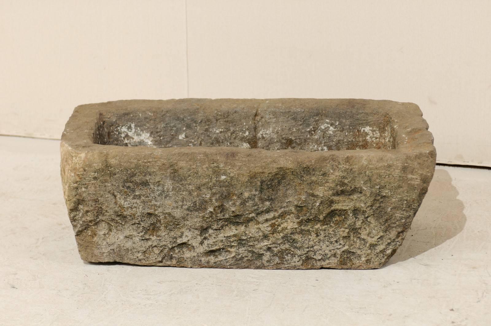A turn of the century (19th-20th century) stone trough / planter from Indonesia. This stone trough is rectangular in shape and has been carved out of a single piece of stone. It is both beautiful and rustic, simplistic in design. A delightful