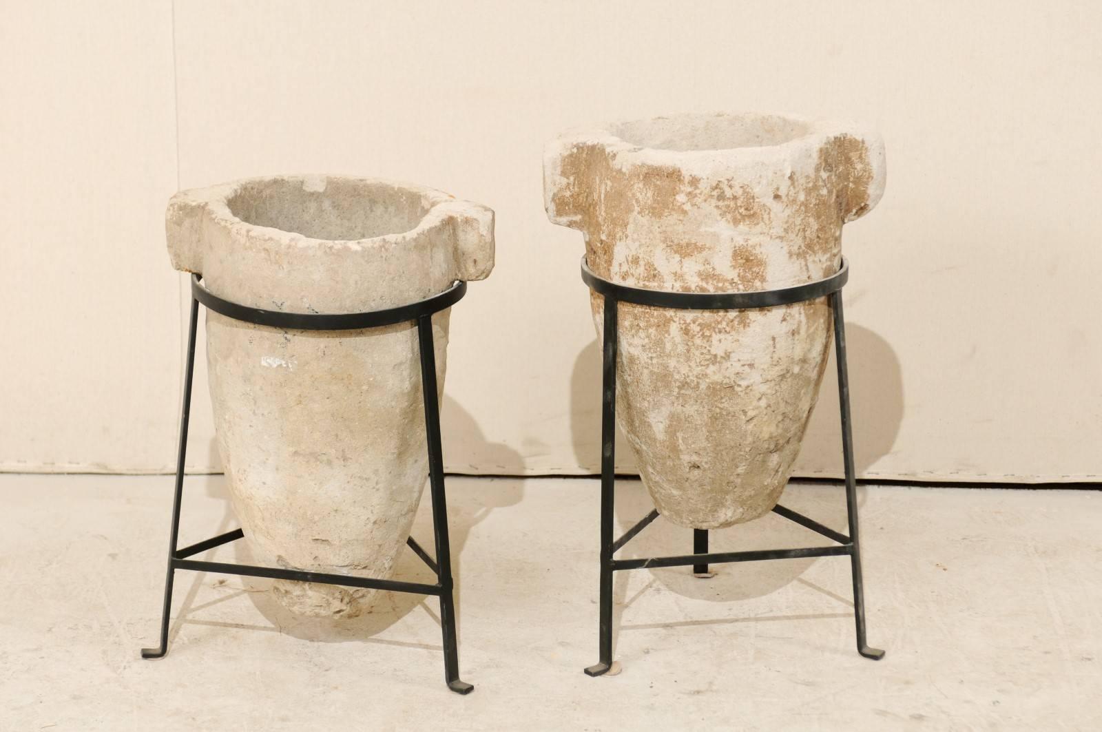 A pair of 19th century Spanish Colonial stone water filters on custom stands. This pair of Central American stone water filters from the early part of the mid-19th century are beautifully displayed in their custom black iron bases. These stone water