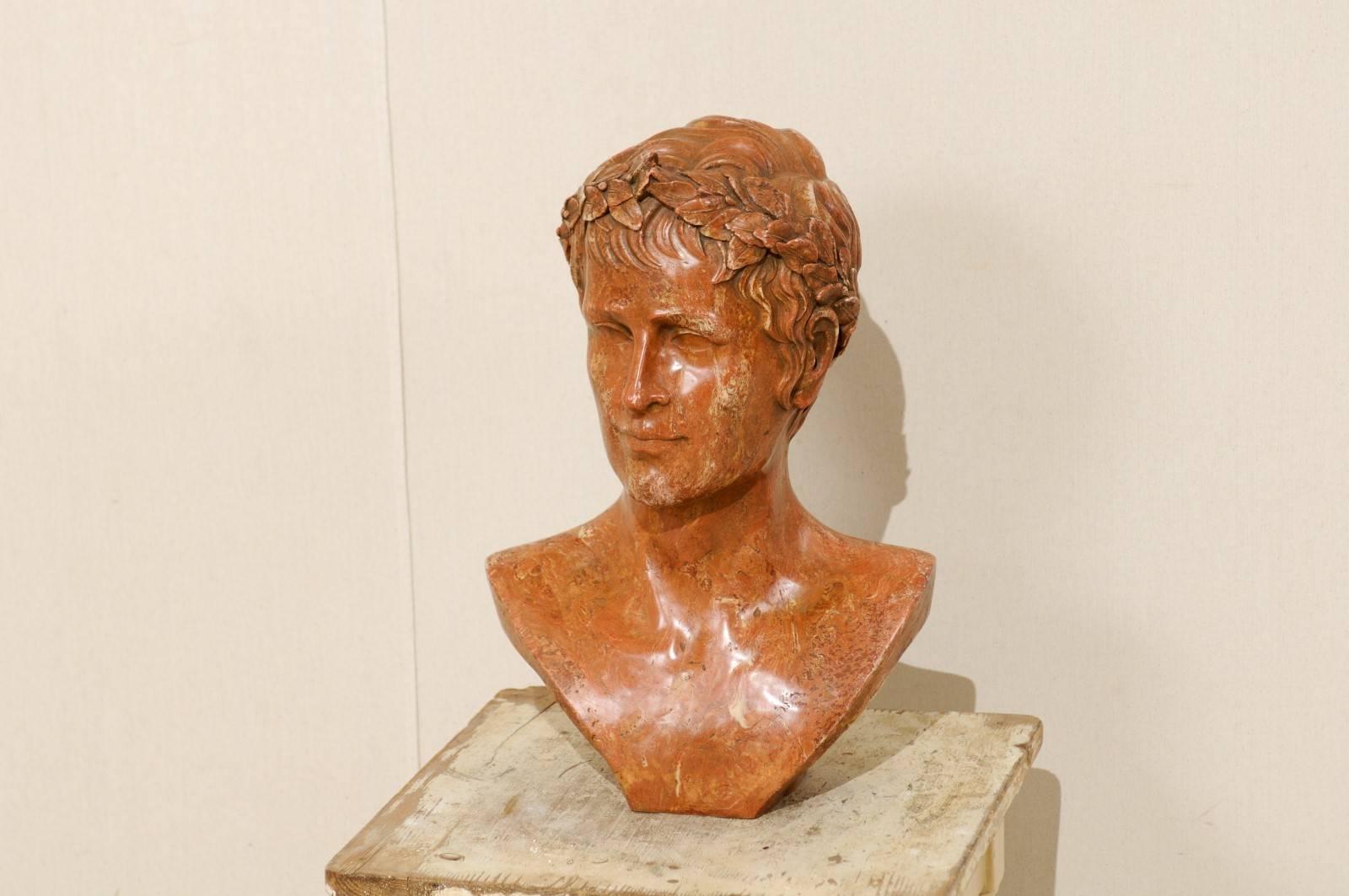 A bust of an unknown Roman Emperor. This bust has been constructed of a marbleized resin, during the last quarter of the 20th century. The colors are primarily warm, in the family of rust and clay with lighter veining throughout. The wearing of