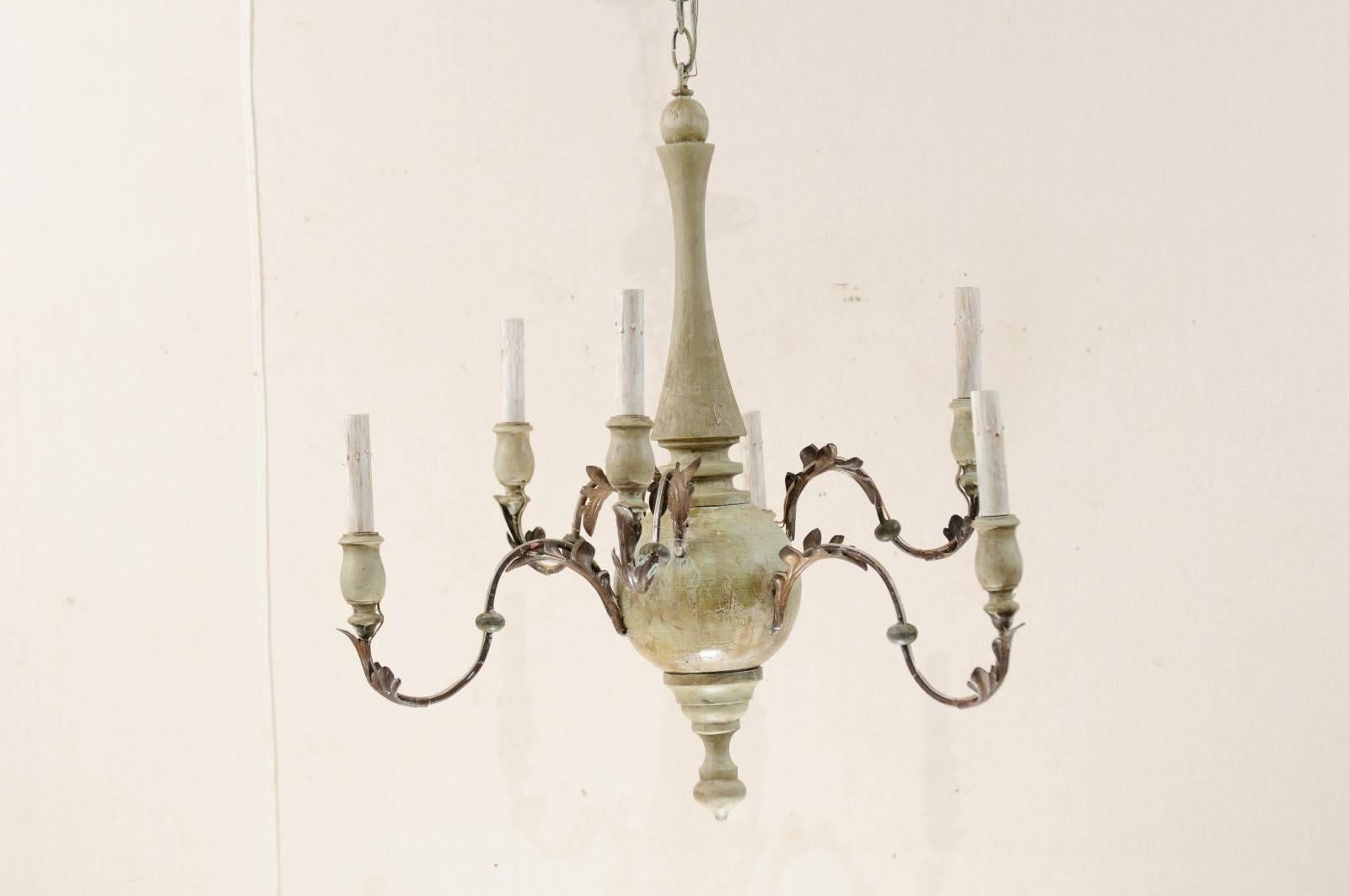 An Italian six-light painted wood and metal chandelier. This graceful mid-20th century Italian chandelier features a carved and painted wood column with metal swag arms extending out, at oscillating heights, from it's bulbous shaped centre. Each arm