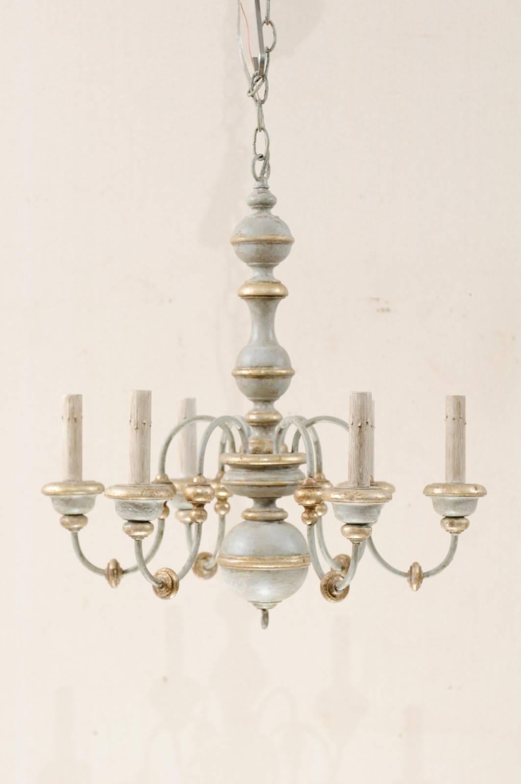 An Italian six-light painted wood and metal chandelier. This lovely mid-20th century Italian chandelier features a carved wood column with fluid s-shaped swooping arms lifting up and out from it's center. This column features a serious of bulbous