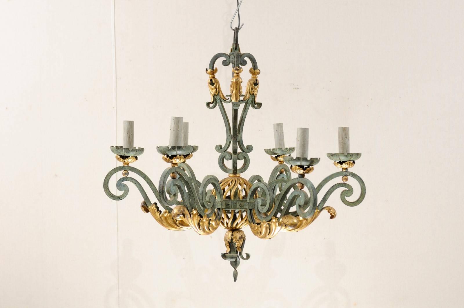 A French six-light chandelier with verdigris finish. This French mid-20th century painted and forged iron chandelier features applied gilded acanthus leaves on the scrolled arms and a pierced orb in its center. This chandelier has been rewired for