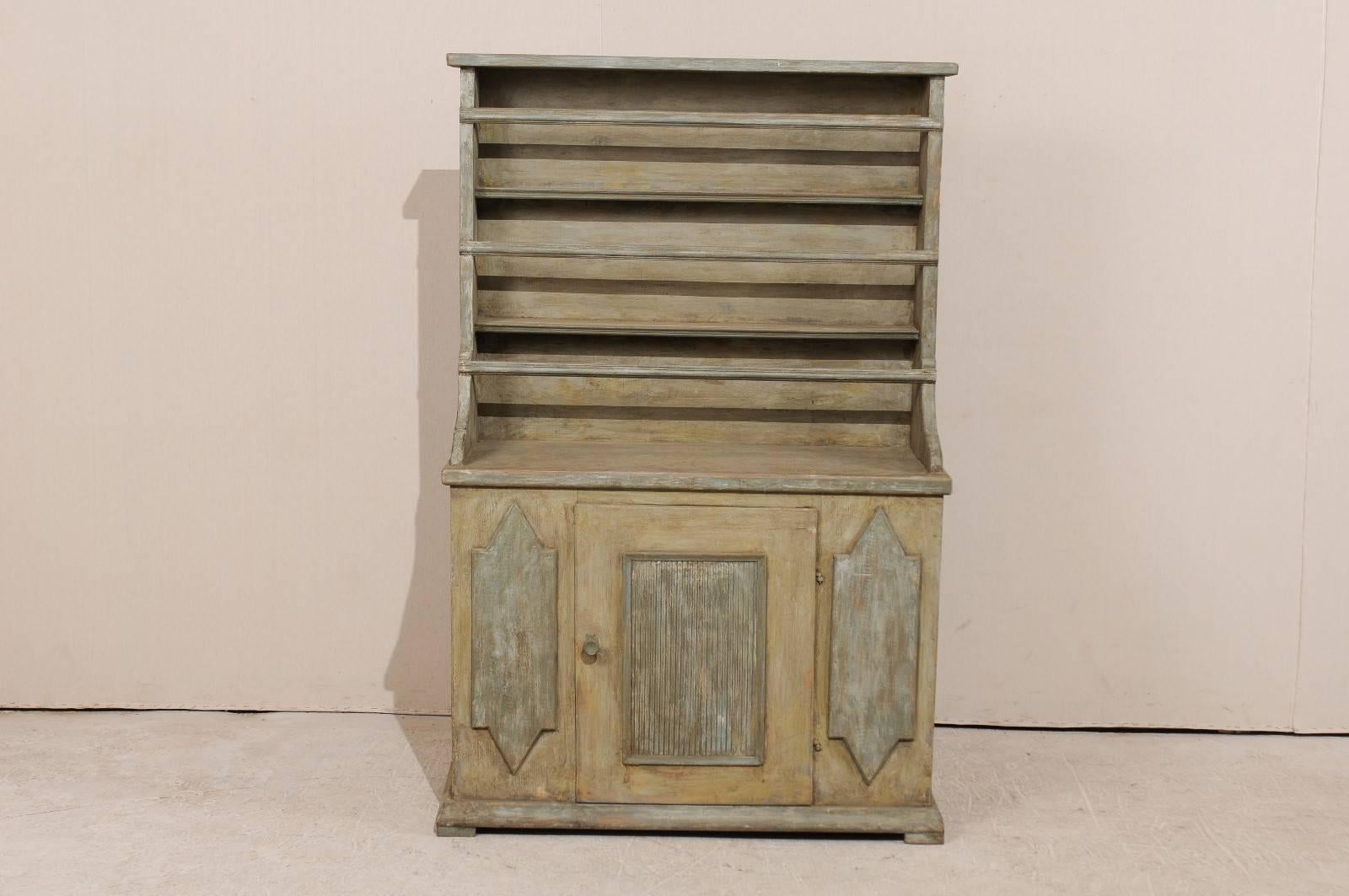 An early 19th century, Swedish painted wood cabinet with plate rack. This period Gustavian Swedish cabinet from the early 19th century features a plate rack top over cabinet bottom with one centered door. The cabinet is accented with a square shaped