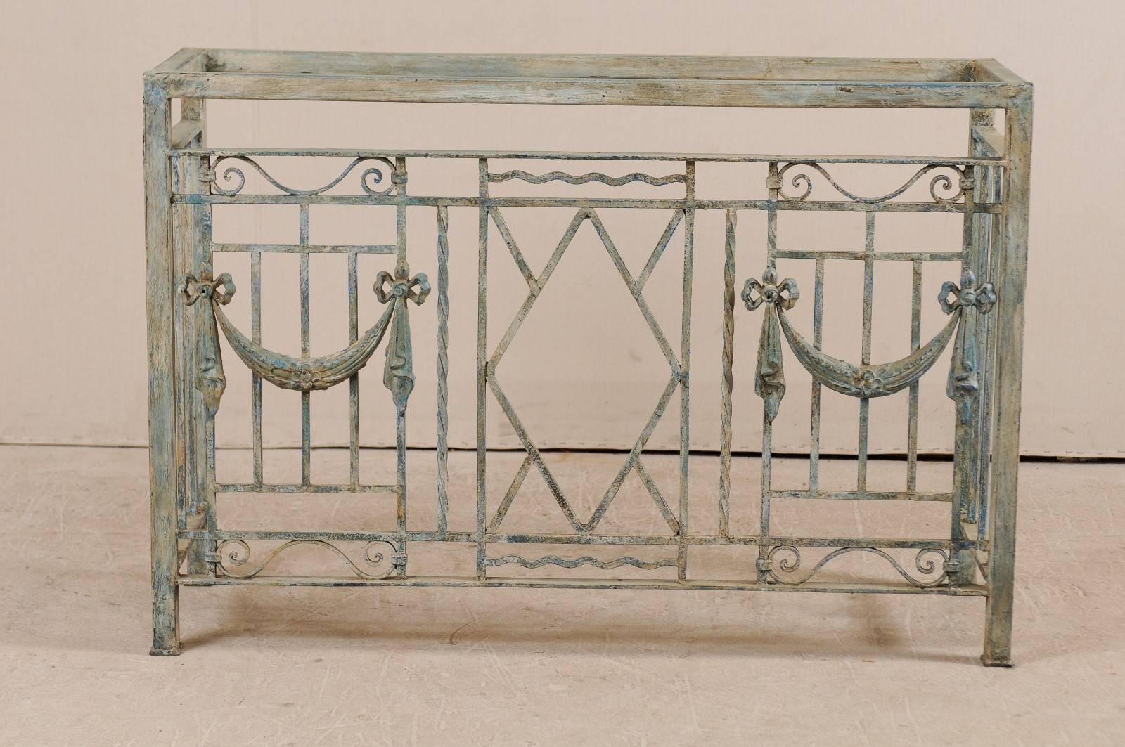A pair of 19th century French painted iron console table bases. This pair of iron consoles are actually old French balcony grates that have been re-purposed into a pair of console bases. Each console features a series of linear bars with the