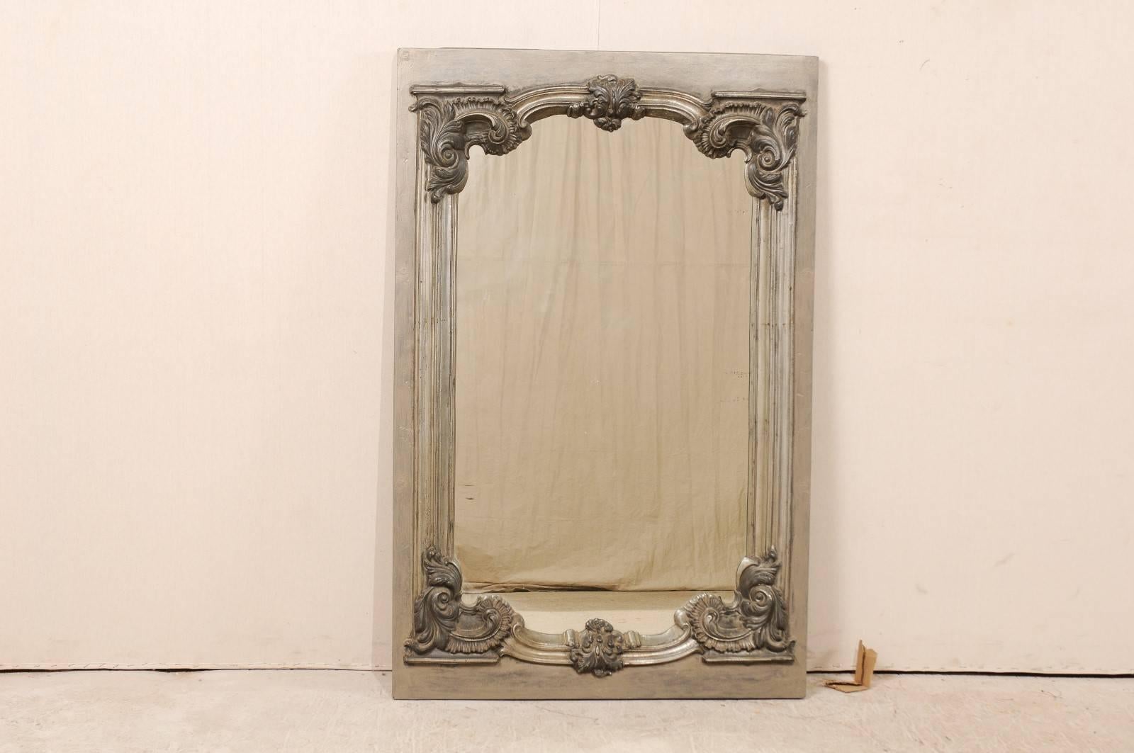 A Swedish early 19th century metal and wood mirror. This Swedish mirror features a beautifully designed inner metal frame with an elegantly sculpted crest and bottom in a with lightly scrolled acanthus leaves. This elegant design is surrounded by a