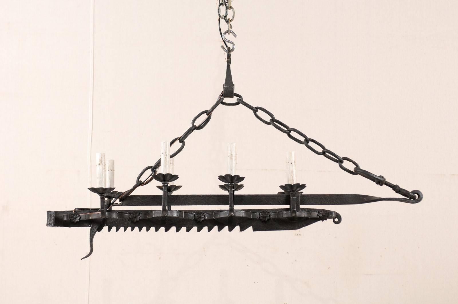 A French Mid-Century, eight-light forged-iron chandelier made from a 19th century spit-jack. A spit-jack is a type of rotisserie that was once common in fireplaces. This chandelier has eight arms, four on each side, which connect to the central