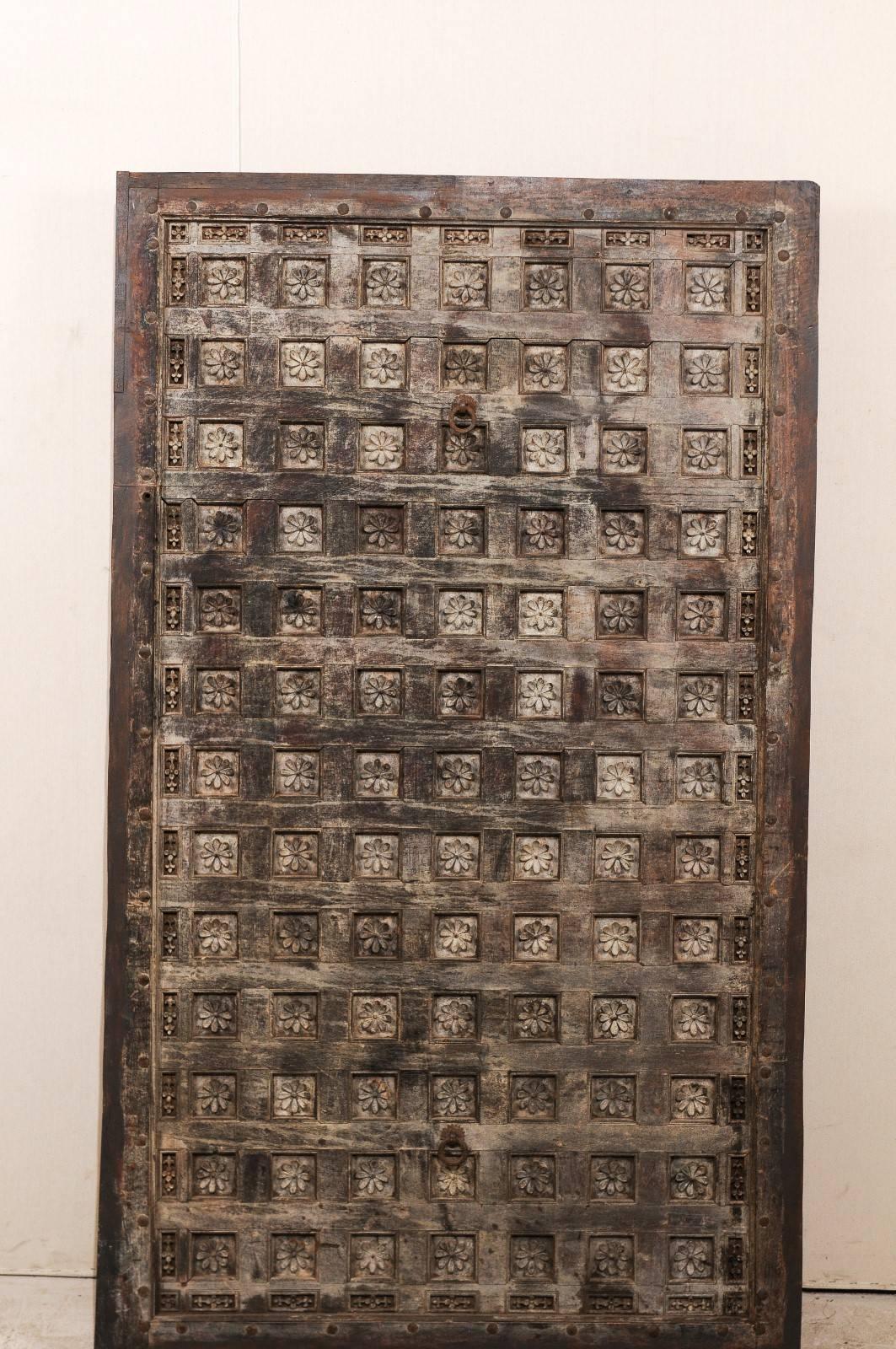 A 19th century wood carved Southern Indian decorative ceiling panel. This rectangular shaped wooden ceiling panel from the Tamil Nadu area features a depiction of delicately carved lotus flowers with the numerous coffered sections. This panel is