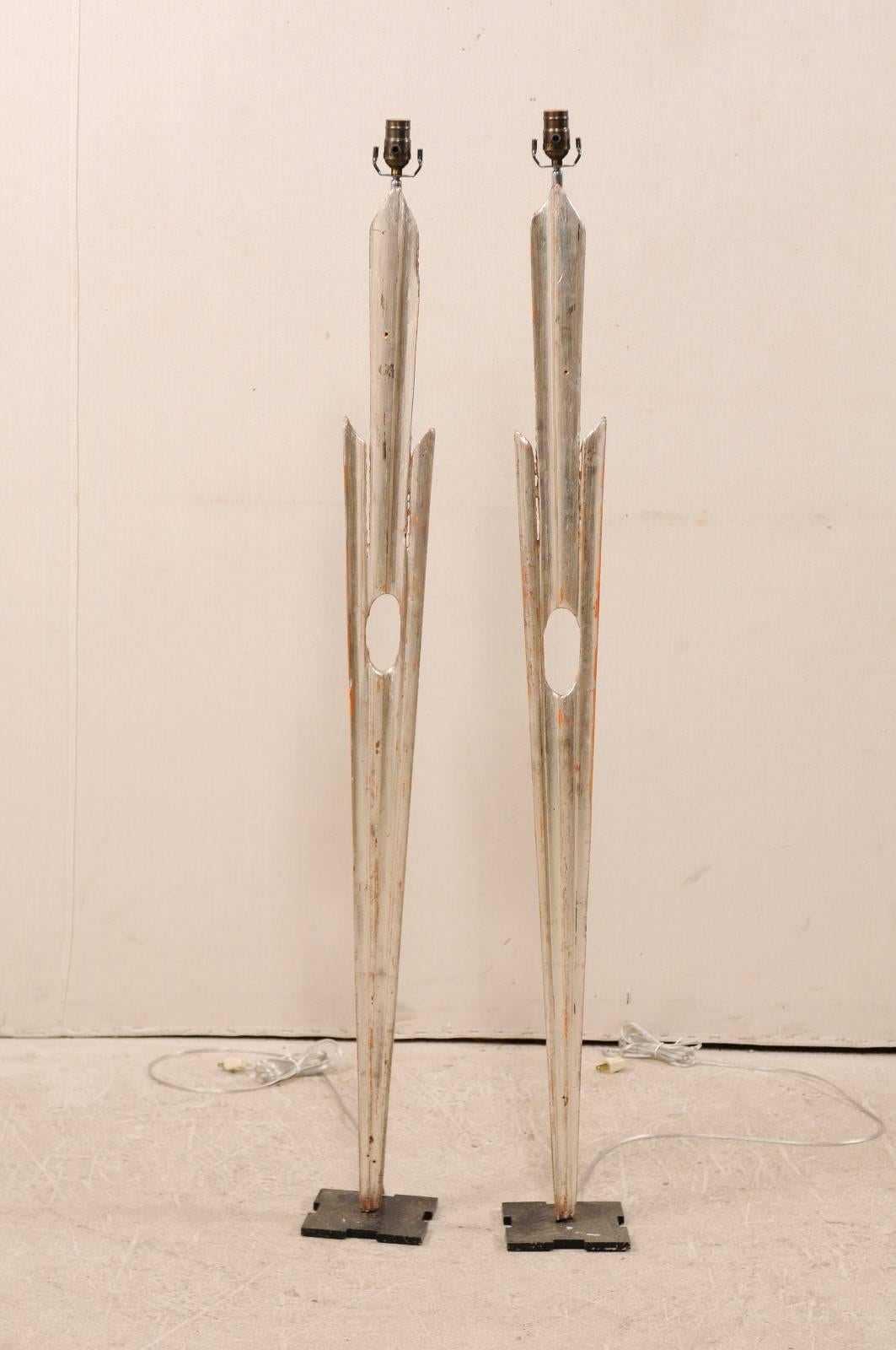 A pair of floor lamps made from Italian, 19th century rays. This pair of tall and slender Italian ray floor lamps have been fashioned out of old silvered star-burst rays and set onto newer, custom black metal bases. The center of the rays have a