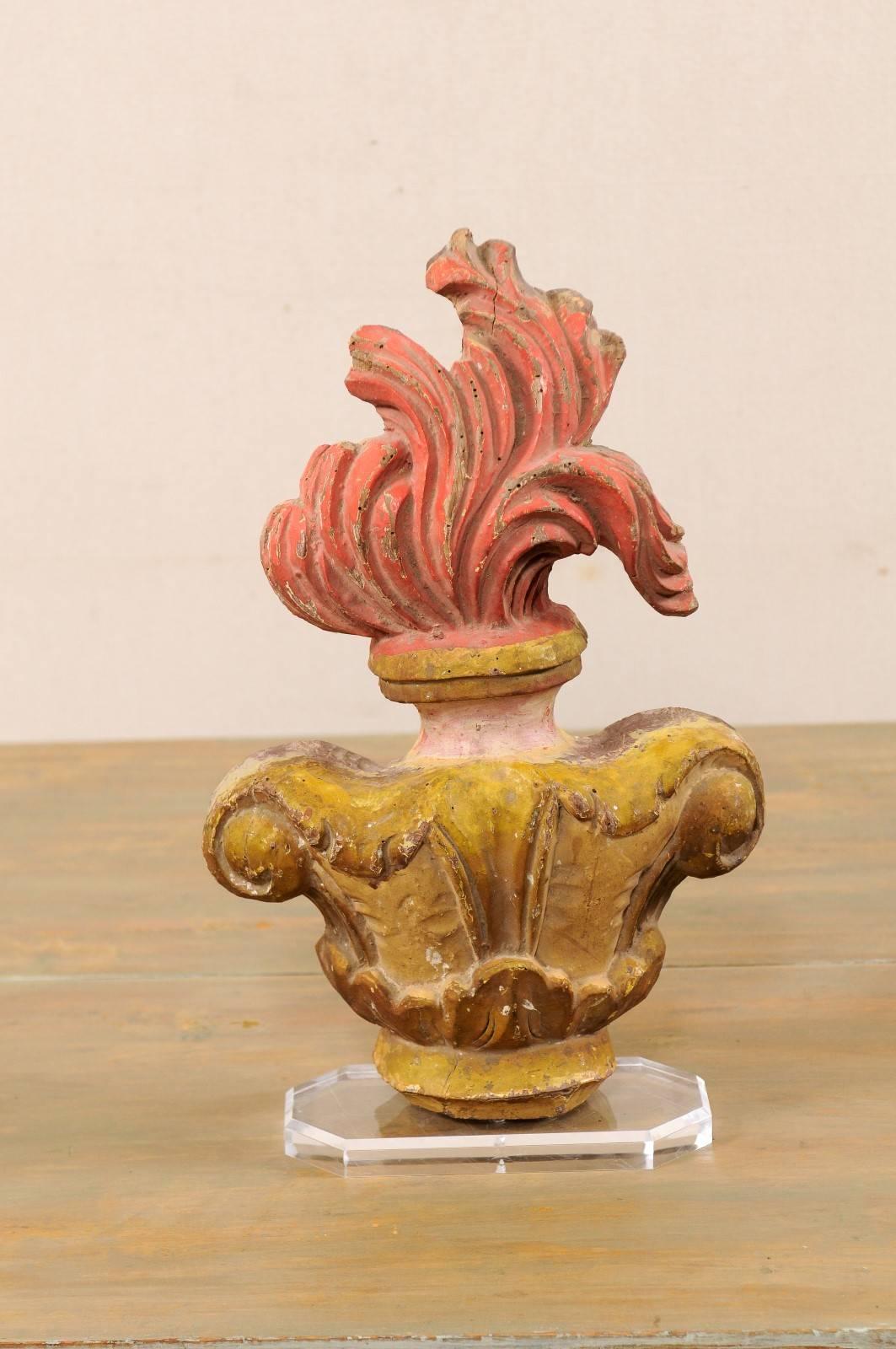 An early 19th century Italian flame carved wood fragment on stand. This Italian fragment features a torch and flame fragment which has been mounted on a custom Lucite base. The fragment has its original paint in colors of mustard and fire with