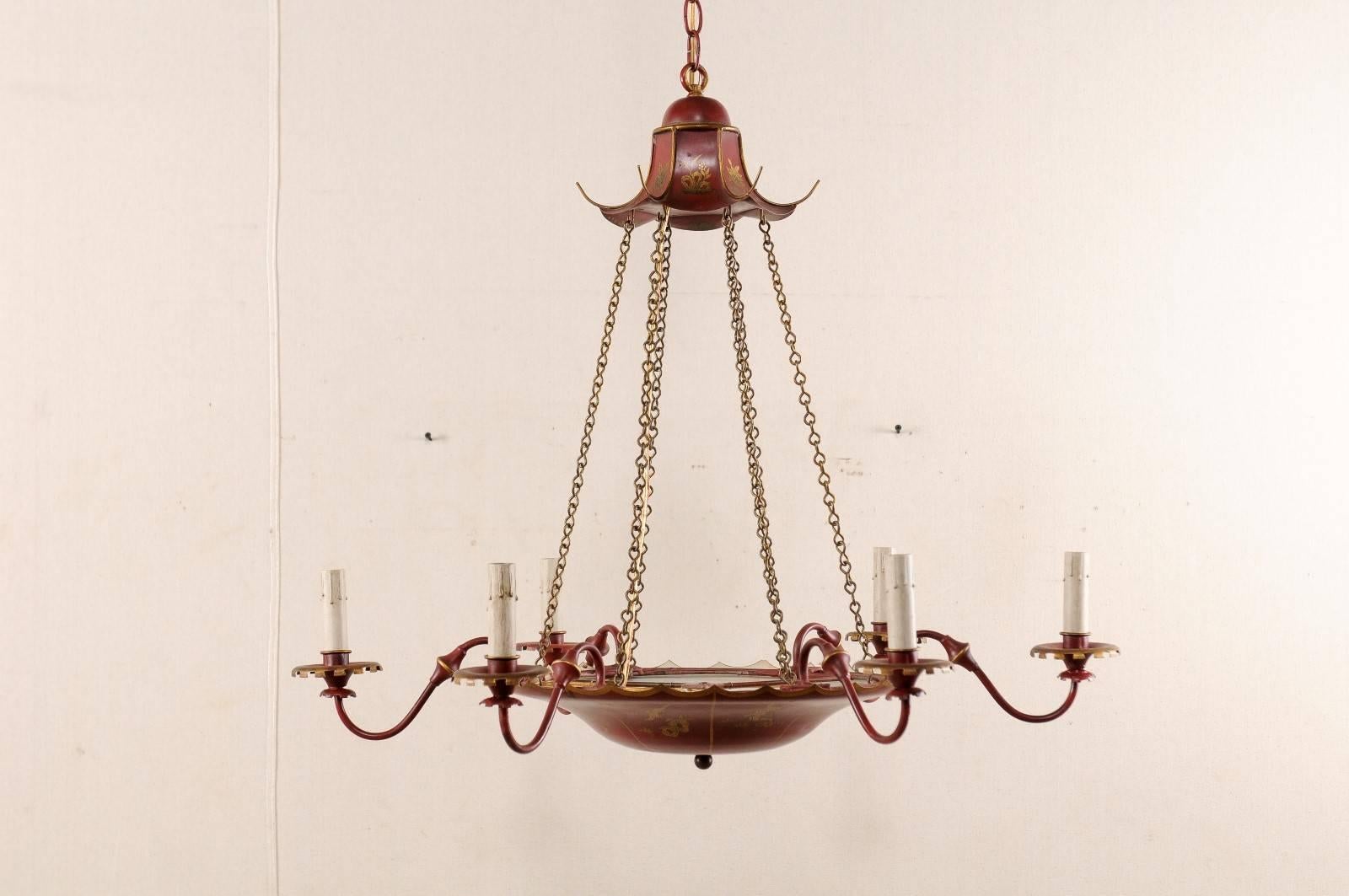 A vintage English red tole six-light chandelier. This English chandelier from the mid 20th century features a red tole finish with chinoiserie decor and painted gold figures. This English light fixture has a circular central red tole basket which is