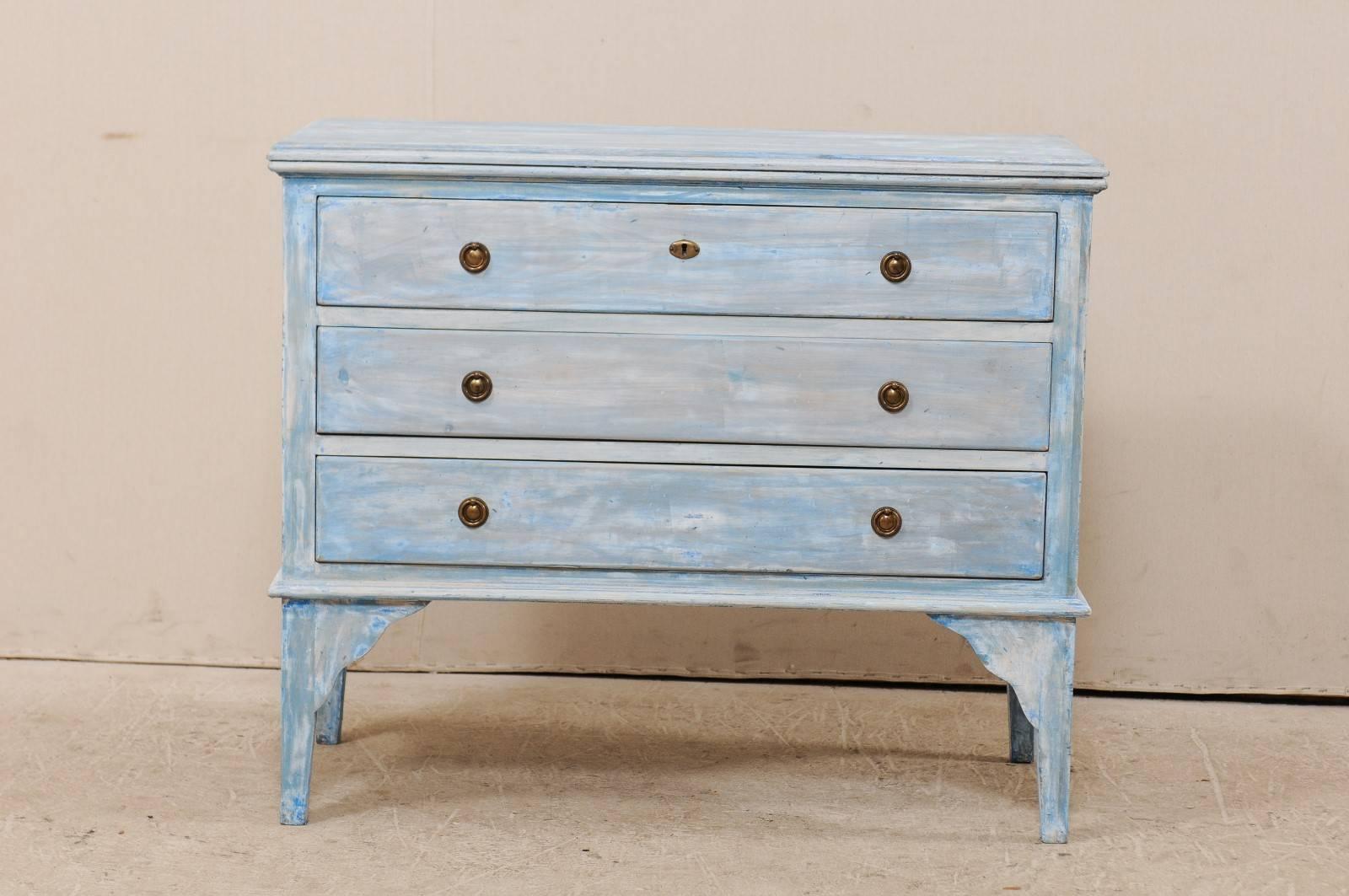 A vintage American painted wood chest. This American chest from the 20th century features three slender drawers and nice clean lines. The drawers are minimally ornamented with brass ring pulls. The chest is raised nicely on slender legs which