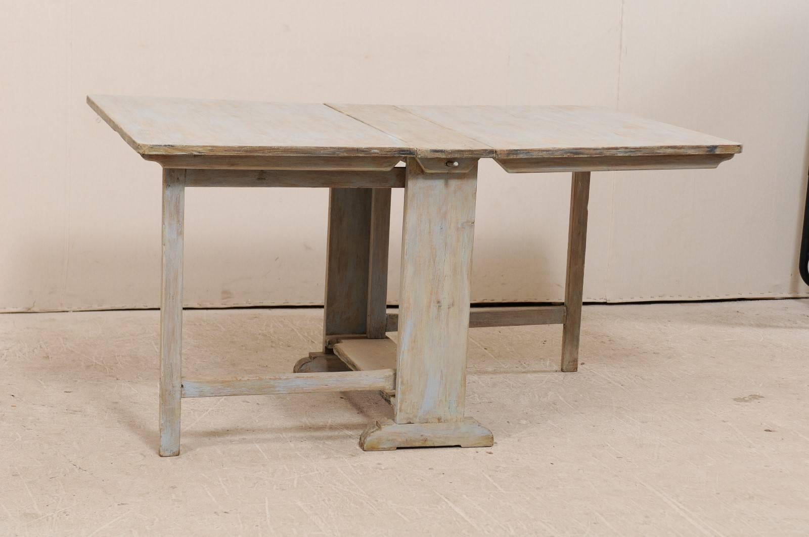A Swedish, 19th century painted wood drop-leaf and gate-leg table. This antique Swedish table from the mid-19th century features two drop-leaf sides that will extend the table to 59
