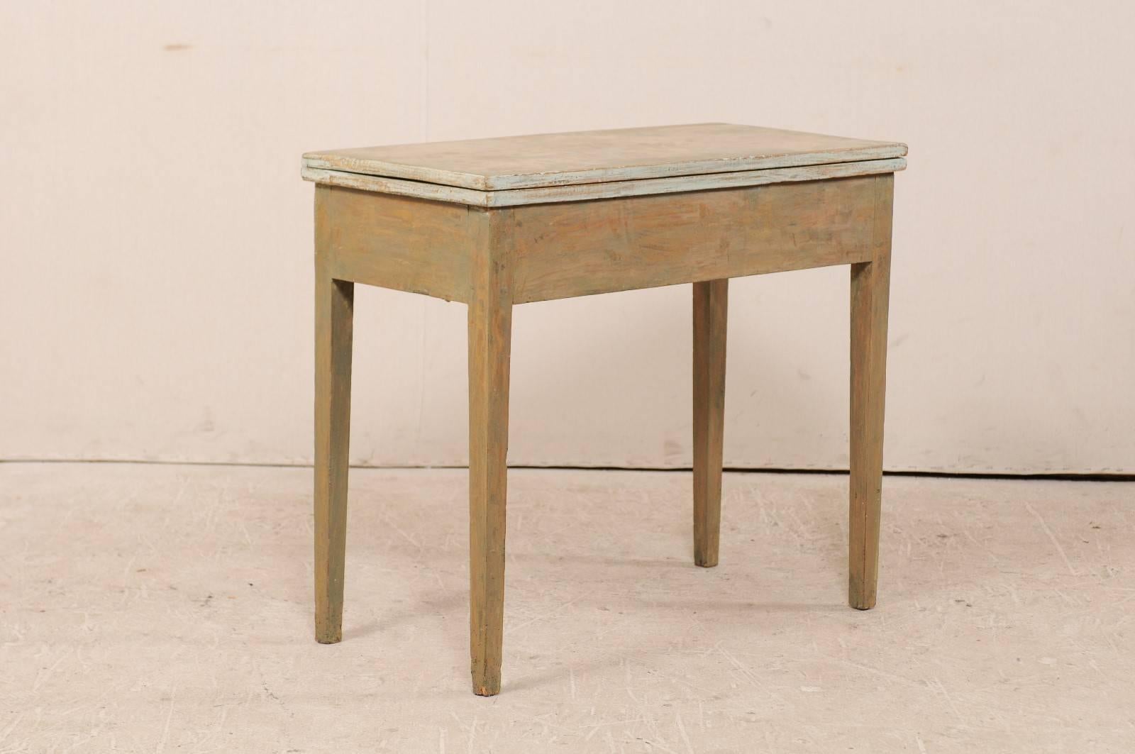 A Swedish 19th century painted wood game, side or small console table. This Swedish table features nice clean lines and a top, that can be opened to double the surface space. This wonderful little table has hidden storage space for game pieces or