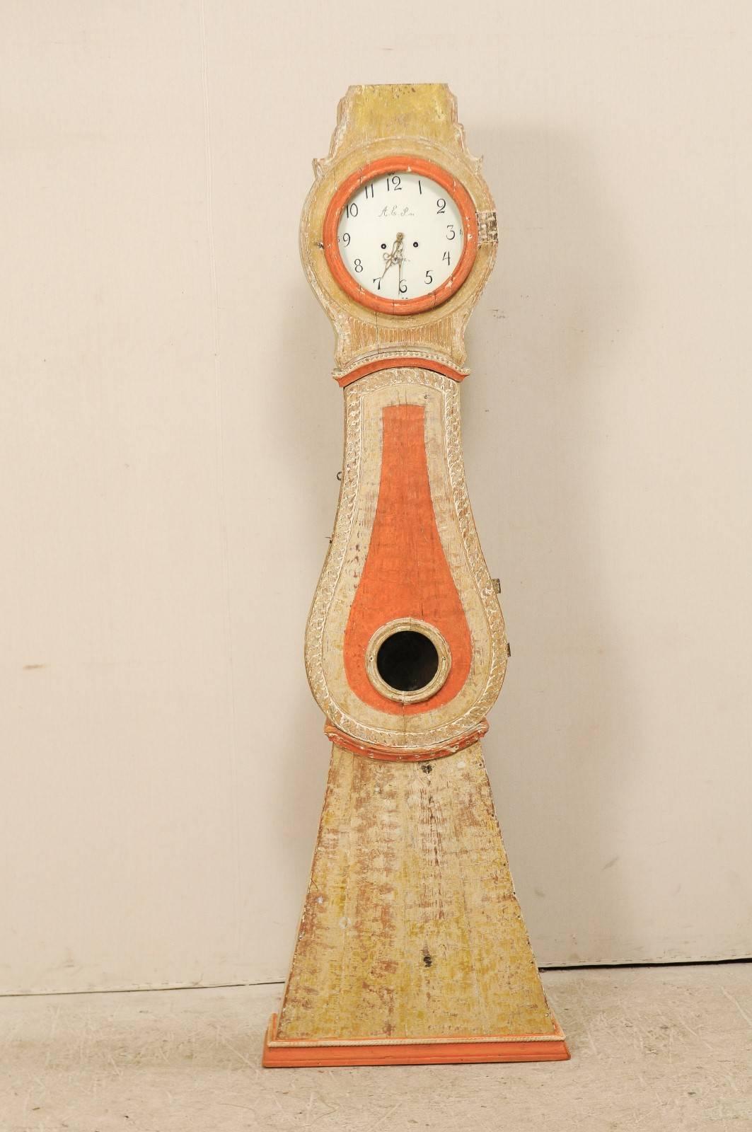A 19th century painted wood Swedish clock. This Swedish clock from the 1820s features a raised crest, round face, a raindrop shaped belly and triangular bottom. This clock retains it's original metal face, hands and movement.  There are vertical and