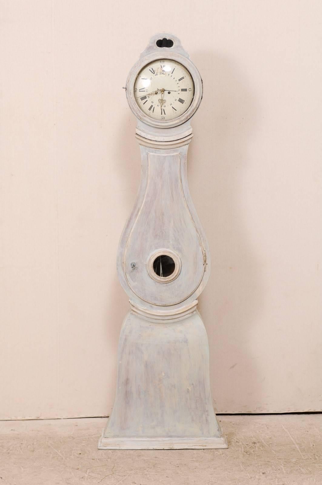 A 19th century Swedish clock. This antique clock from the central area of Sweden features a flattened arch shaped raised bonnet with pierced center, an unusual and beautiful face and accent trim about the neck and waist.  This clock retains it's